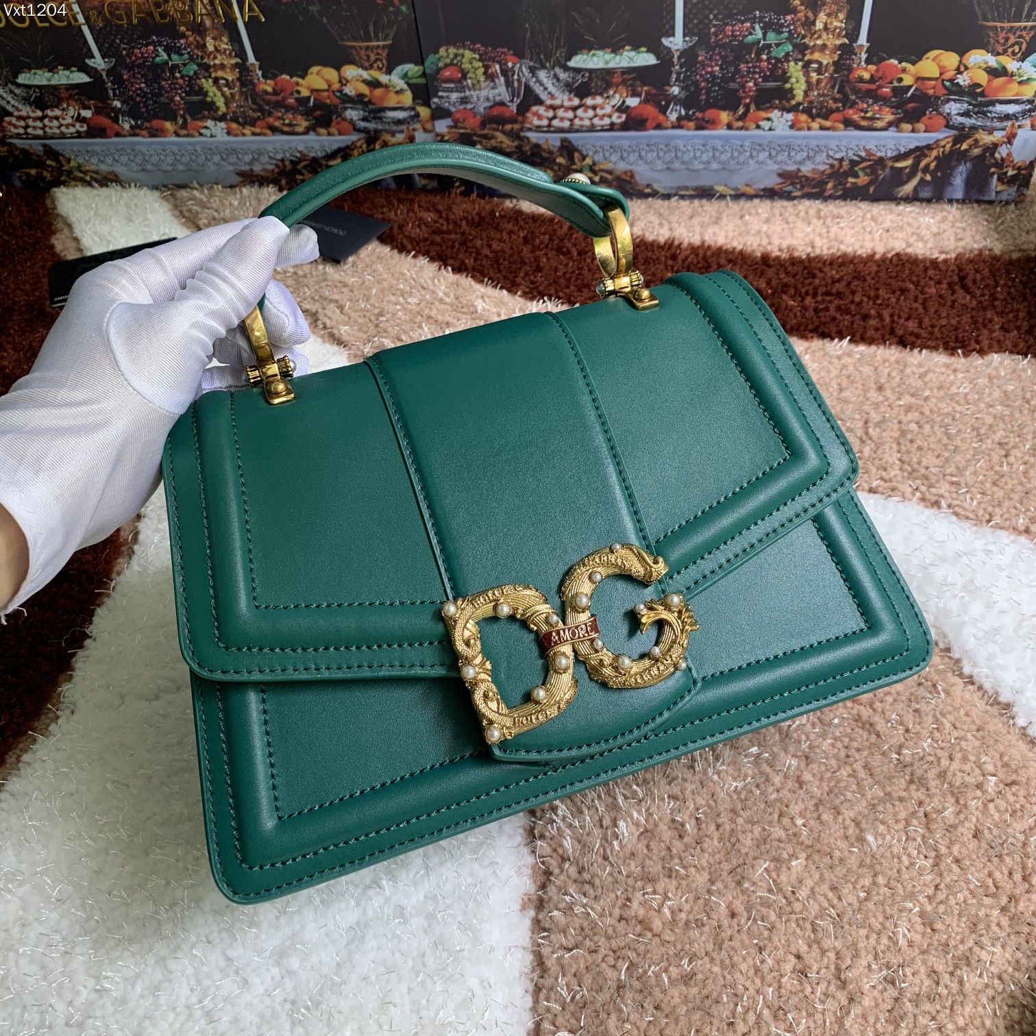 杜嘉班纳 【Dolce Gabbana 杜嘉班纳】顶级原单 独特之处，彰显在红色卷轴上构成“Amore”的巴洛克式风格❤️配装饰有珍珠和连接 DG 两个字母的“Amore”字母卷轴的镀复古黄铜金属 DG 徽标，隐藏式按压扣开合，顶部小牛皮把手配两侧珍珠徽标细节，可调节、可拆卸小牛皮肩带，内部撞色纳帕小牛皮结构，配拉链口袋和品牌滑索以及有中间分隔物的两个隔间 ➰细腻手工制造 ??
