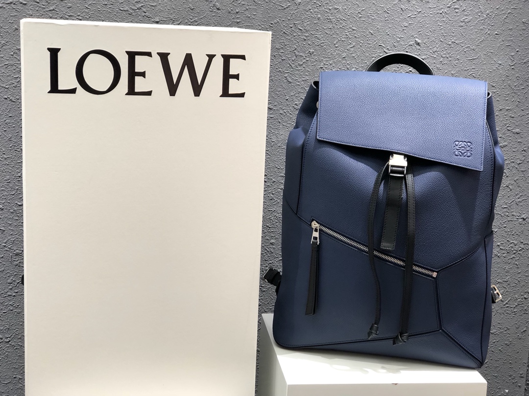 NO:341130,The latest men's series of special Loewe Puzzle Backpack in stock blue. The size is 33x44.5x19 cm, with a super large capacity, unique and innovative cube shape, precise tailoring creates a sense of volume, comfortable touch, and extremely practical. This stylish backpack can be carried on both shoulders, one shoulder or carried by hand, and the 69-81cm long strap can be adjusted to the most comfortable length. It is made of imported Spanish calf leather and feels gentle and comfortable. It is made of soft grain calf leather. The designer thoughtfully designed a small zipper pocket on the front and a small insert pocket on the side to hold personal belongings, which is very convenient to use. The drawstring double-layer privacy 