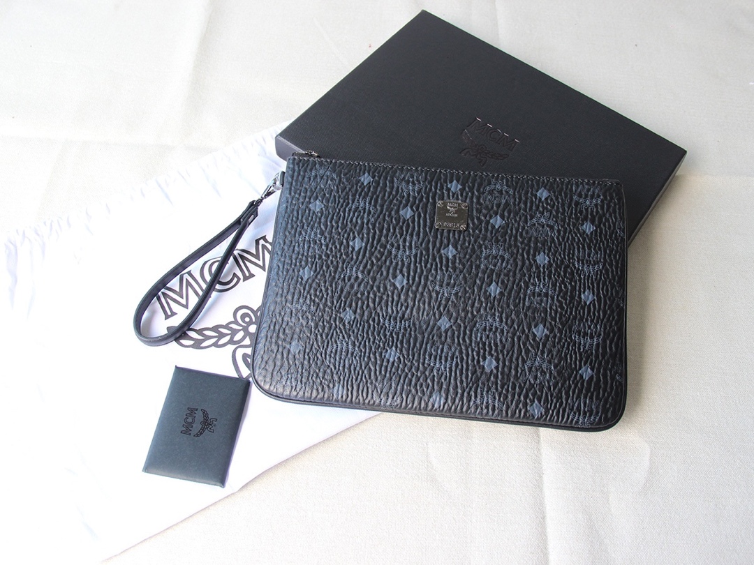 Top-tier MCM Visetos wristlet series handbag, clutch bag, model number 20082, seamlessly blends unique practicality with exquisite style, featuring a convenient wrist strap. The spacious interior includes a zip pocket, top zip closure, and luxurious faux nappa leather lining. Dimensions: 21x29 cm. image 1