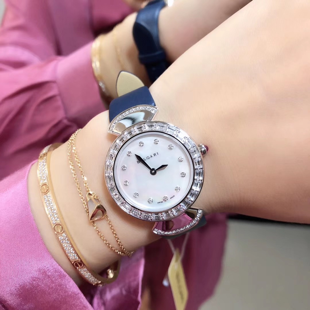 Bvlgari 宝格丽圈口镶石由全手工镶施华洛钻打造而成 把头微镶着一粒红宝石 表盘有两种：天然珍珠贝壳面