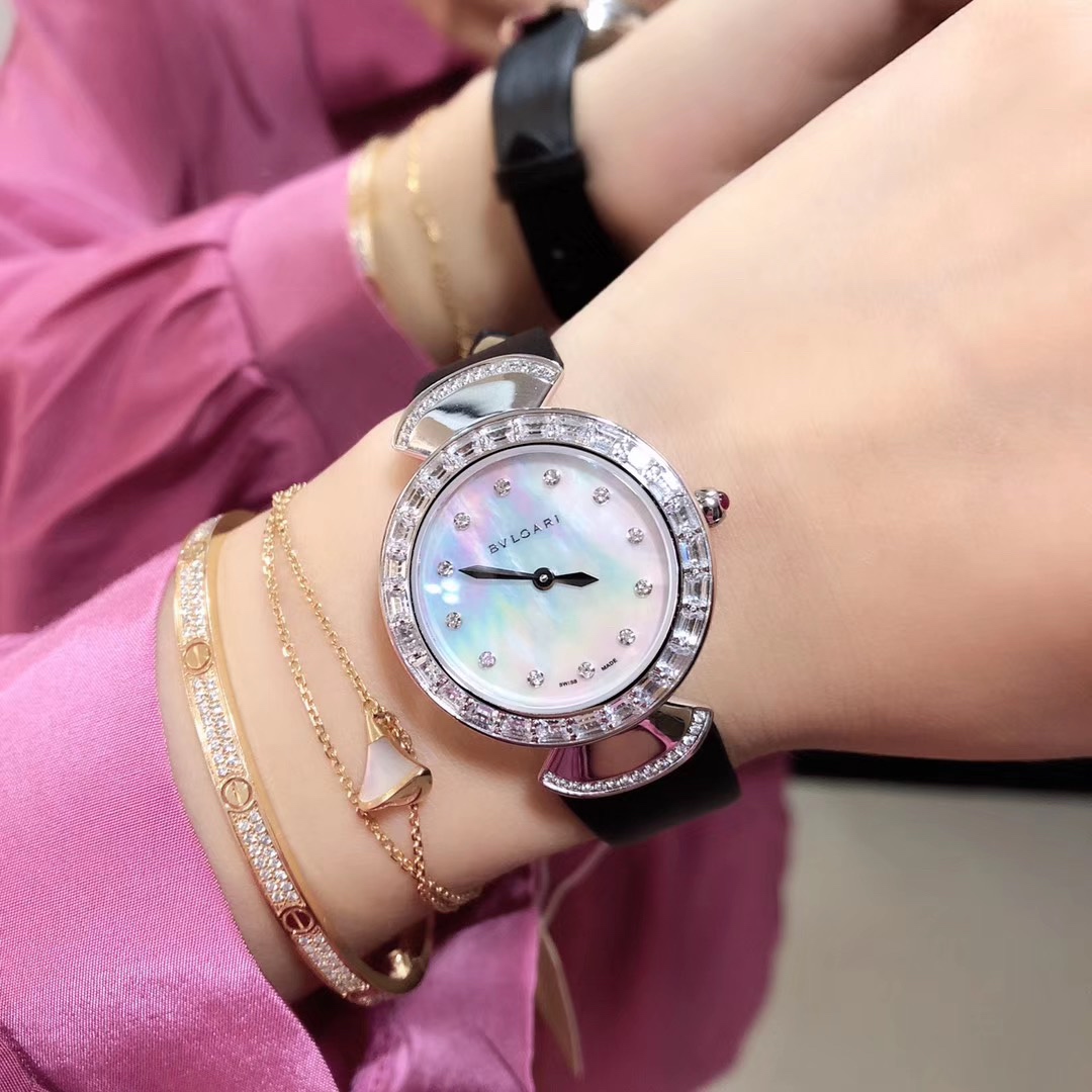 Bvlgari 宝格丽圈口镶石由全手工镶施华洛钻打造而成 把头微镶着一粒红宝石 表盘有两种：天然珍珠贝壳面