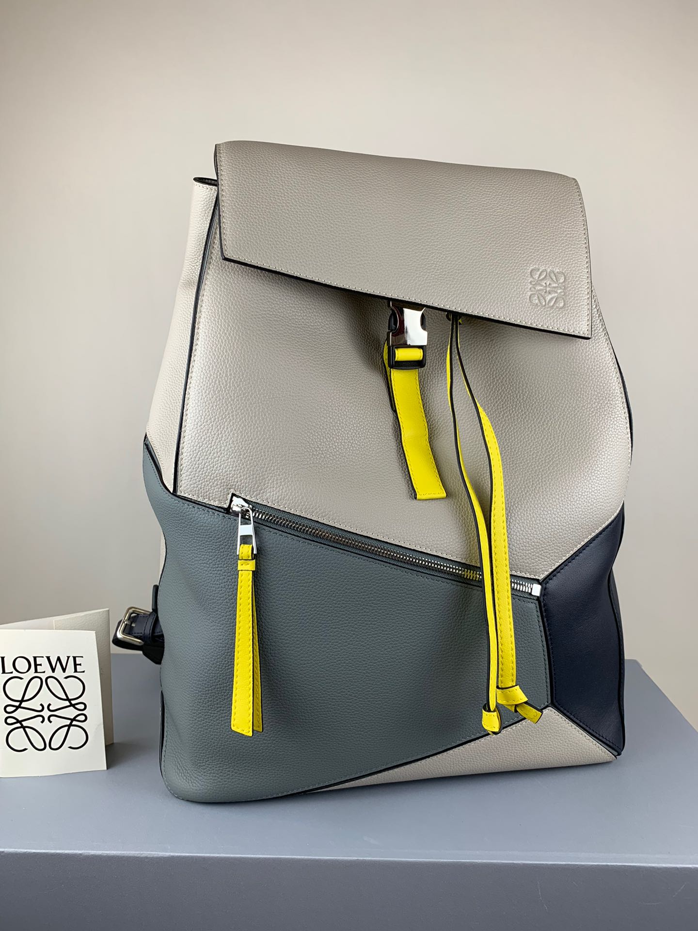 NO:341162,Super Grade Gray and White LOEWE Puzzle Backpack color is new. The model 324 is super large in capacity, the cube shape is unique and innovative, and the precise tailoring creates a sense of volume!  Soft grain calfskin, a small zipper pocket on the front, and a small insert pocket on the side to hold personal belongings, very convenient to use 33-44.5-19 The same style for men and women, the best Loewe, loewe, loewe, cowhide19860909特级 灰白 LOEWE Puzzle Backpack色上新 型号324超大容量,立方体造型独特创新,精确剪裁营造出体积感！柔软粒面小牛皮,前幅一个小拉链口袋,侧面一个小插袋可放随身物品,非常方便使用33-44.5-19 男女同款,特级罗意威,loewe,loewe,cowhide,Bag