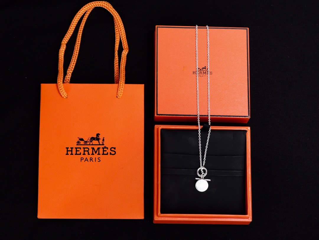 Collier HERMES argenté avec pendentif rond