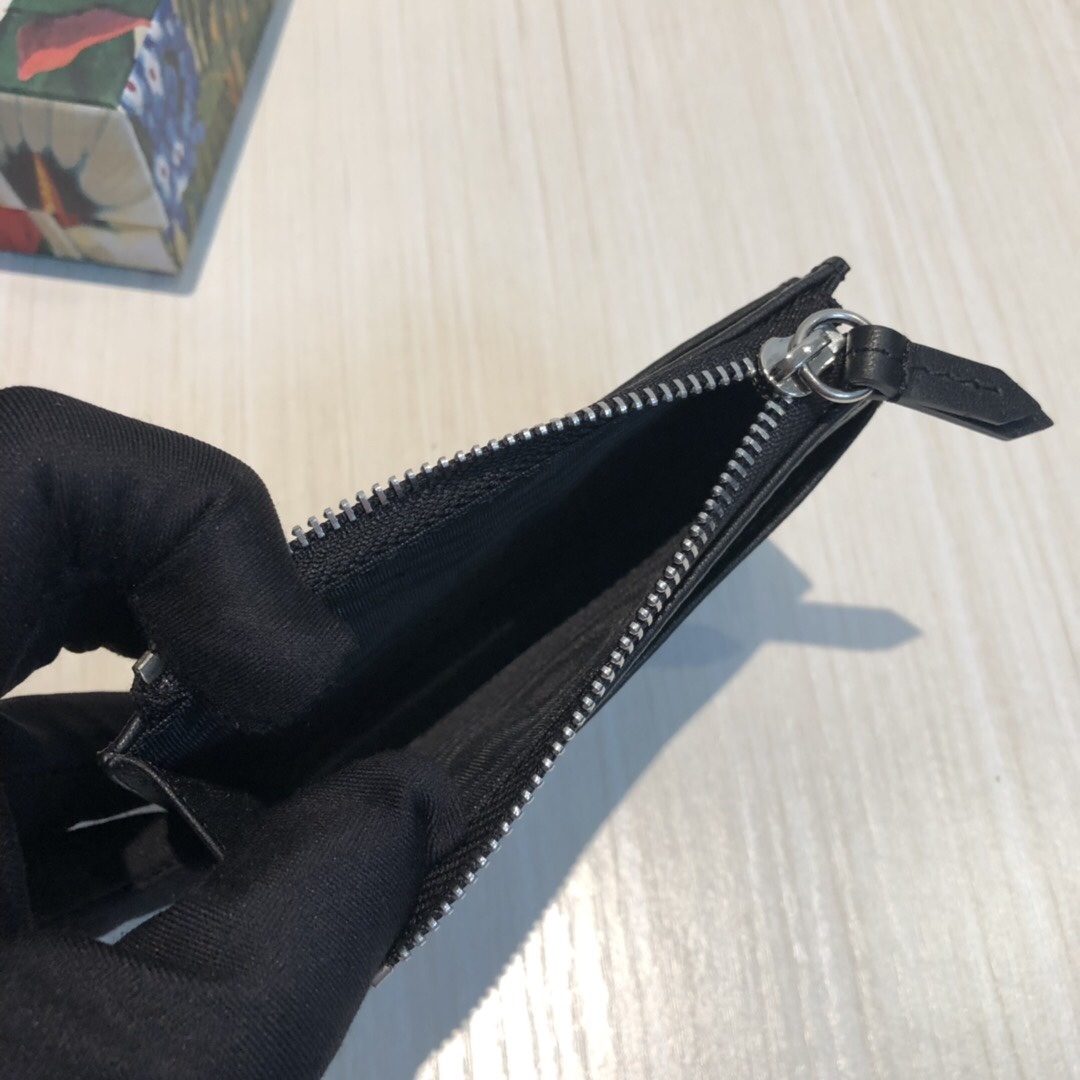 这款纤薄卡包带有多个口袋和拉链隔层,以带皮革包边的品牌交织字母帆布制成。四角处饰有小巧动物印花,这是20