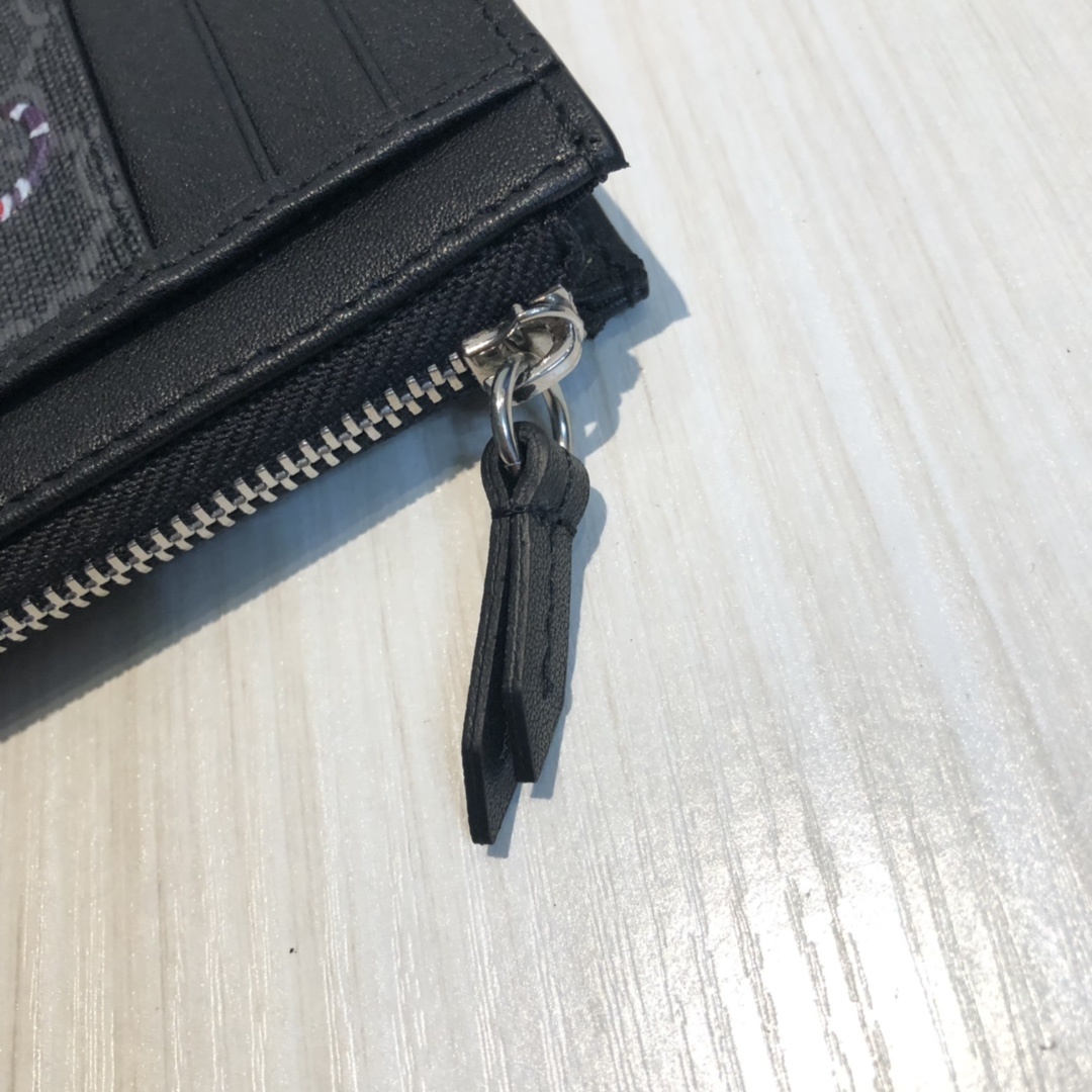 这款纤薄卡包带有多个口袋和拉链隔层,以带皮革包边的品牌交织字母帆布制成。四角处饰有小巧动物印花,这是20