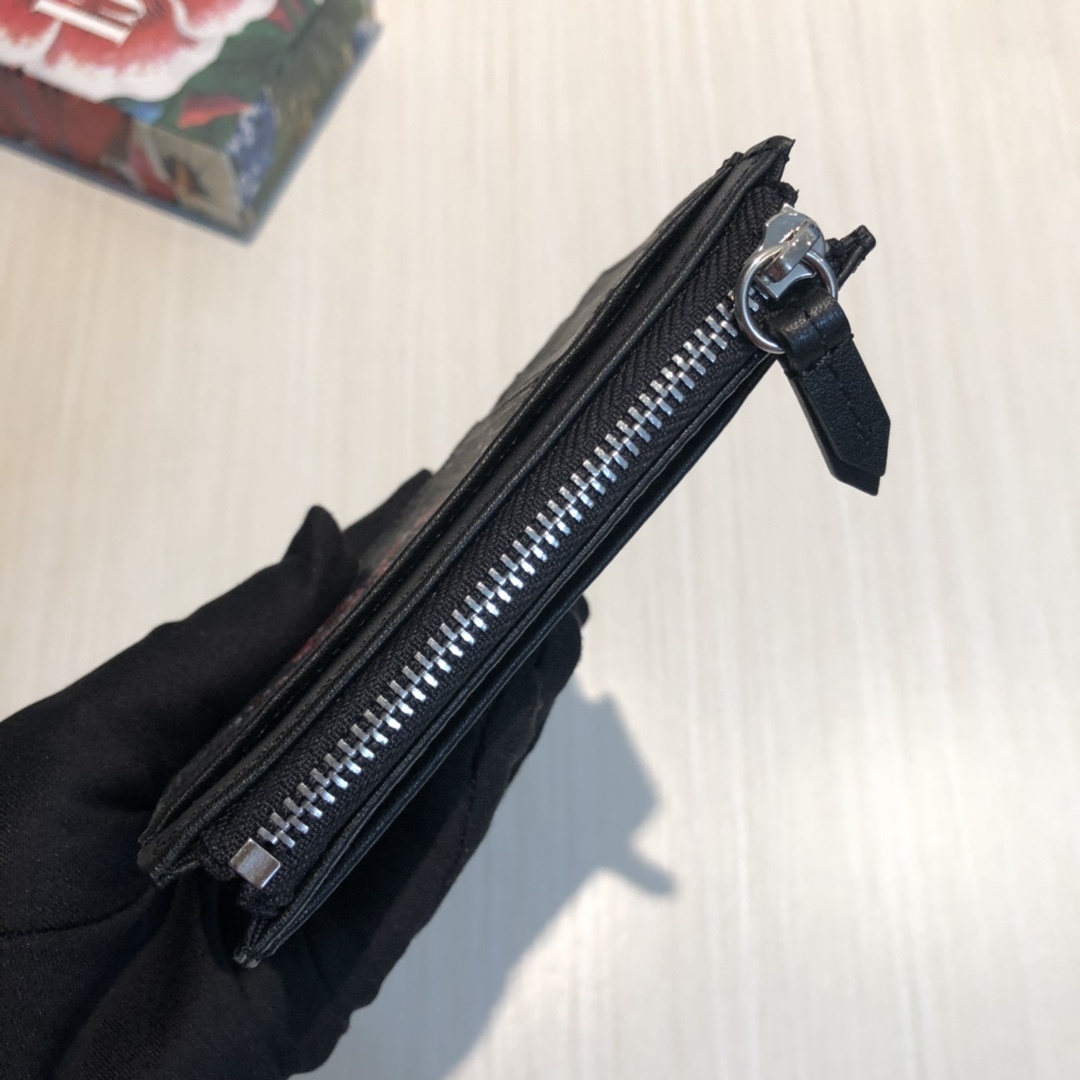 这款纤薄卡包带有多个口袋和拉链隔层,以带皮革包边的品牌交织字母帆布制成。四角处饰有小巧动物印花,这是20