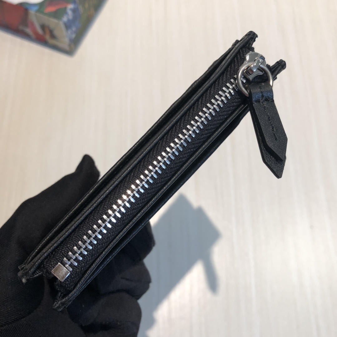 这款纤薄卡包带有多个口袋和拉链隔层,以带皮革包边的品牌交织字母帆布制成。四角处饰有小巧动物印花,这是20
