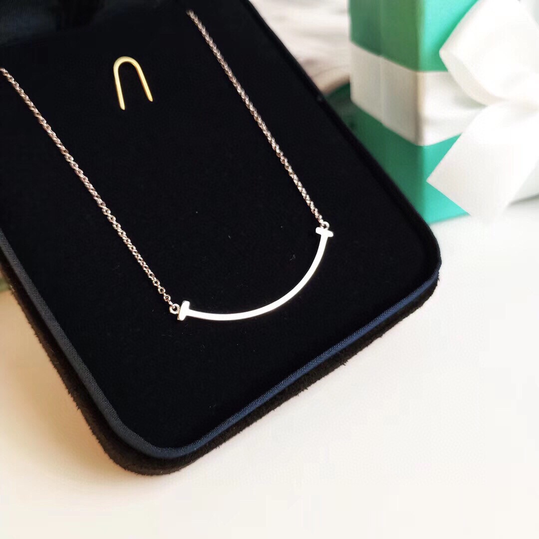 NO:723153,The classic Tiffany & Co. smiley face necklace without diamonds, clavicle chain, the same style as the star. The strong graphic lines perfectly present the simplicity and purity of the Tiffany T series. The elegant curves of this pendant exude eternal elegance. Counter genuine +, size 16 inches 18 inches. Comes with full counter set, Tiffany necklace, tiffany, necklace19860909经典款Tiffany & Co.笑脸不带钻项链锁骨链明星同款 强烈的图形线条,完美 呈现Tiffany T系列的简约纯粹.该款吊坠优雅的曲线散发着永恒的高雅. 专柜正品+,尺寸16英寸18英寸 配专柜全套装,蒂芙尼项链,tiffany,necklace,Jewelry