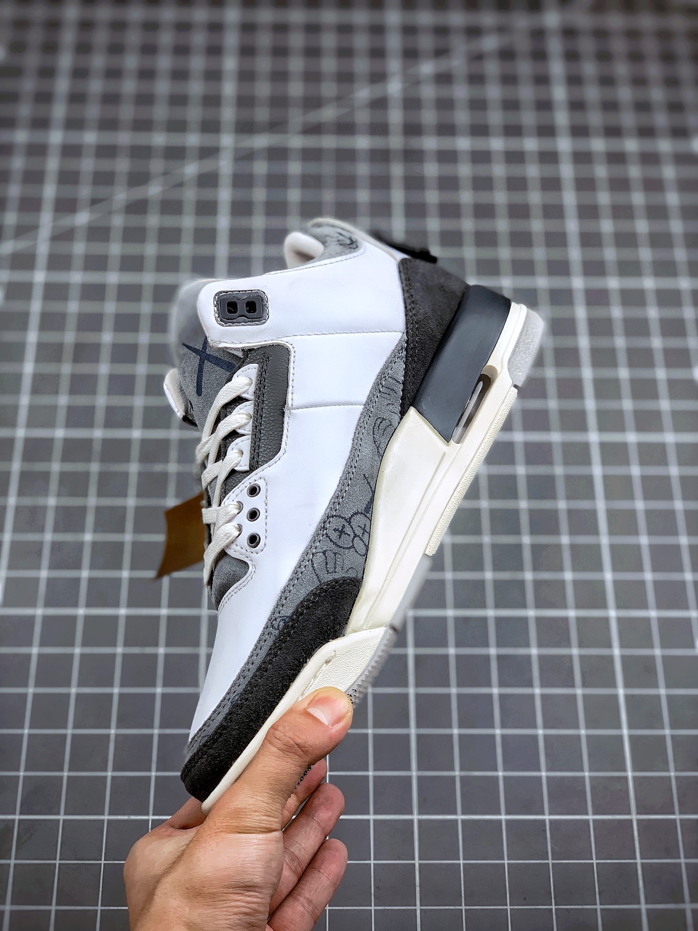 460 KAWS  Air Jordan 3  鞋款采用灰白的配色并将 KAWS 的形象融入到 Air Jordan 3