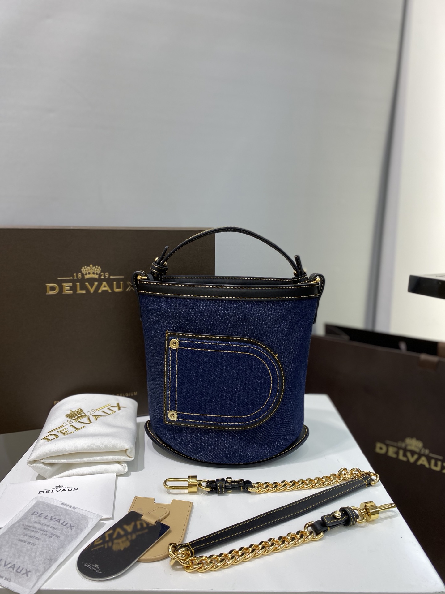 Delvauxpinbucket丹宁系列采用日本棉质丹宁布黑色光泽小牛皮装饰细节深蓝色丹宁面料点缀黄色十