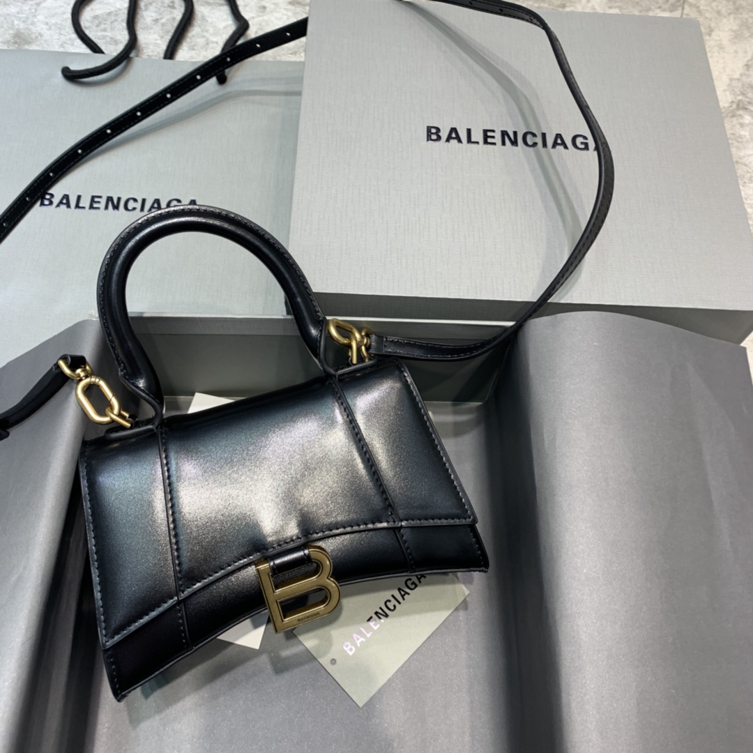 【mini号】原单Balencia巴黎家，本季重磅【平纹黑色】沙漏包，独特的标志性弧线形状造型极具辨识度，一眼就让人眼前一亮呀超炫酷，外观呈现一轮半月状上坠一个金属B形拉环牛皮质感也非常感人非常有腔调，日用品还是精挑细选百搭又潮流，今年这款巴黎世家沙漏包一定会火的一塌糊涂，优雅精致又个性，一眼就让人眼前一亮，不想被人注意到都难啊，手拎斜挎都好看到爆。绝对是女神们的最爱，当然我也爱shi了！可盐可甜要的就是这效果。容量亲测：手机、零钱包、粉饼、口红、充电宝、钥匙、小包纸巾，统统可以轻松装入，支持验货。尺寸：--cm