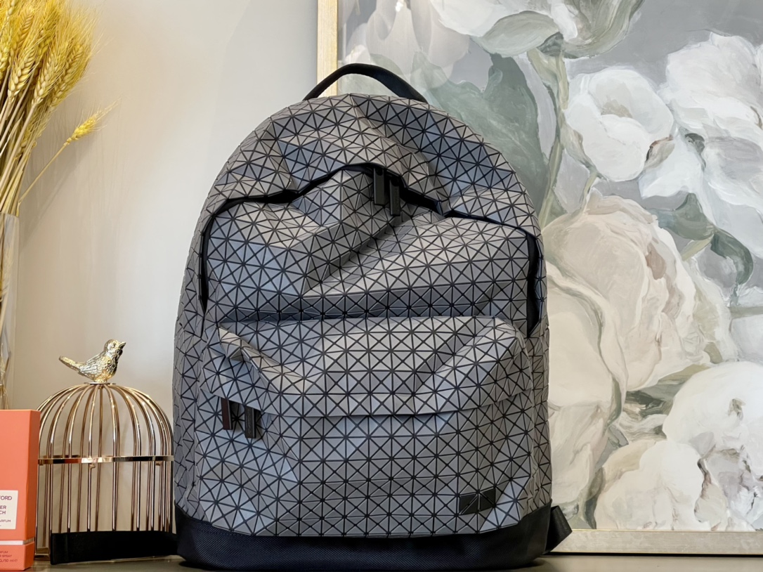 Foto reali dello zaino Issey Miyake in silicone grigio scuro. Progettato secondo principi ergonomici per adattarsi perfettamente alla forma della schiena, garantisce traspirabilità e una distribuzione equilibrata del peso, riducendo la pressione il massimo comfort anche dopo un uso prolungato. compagno ideale le tue uscite! [ ]