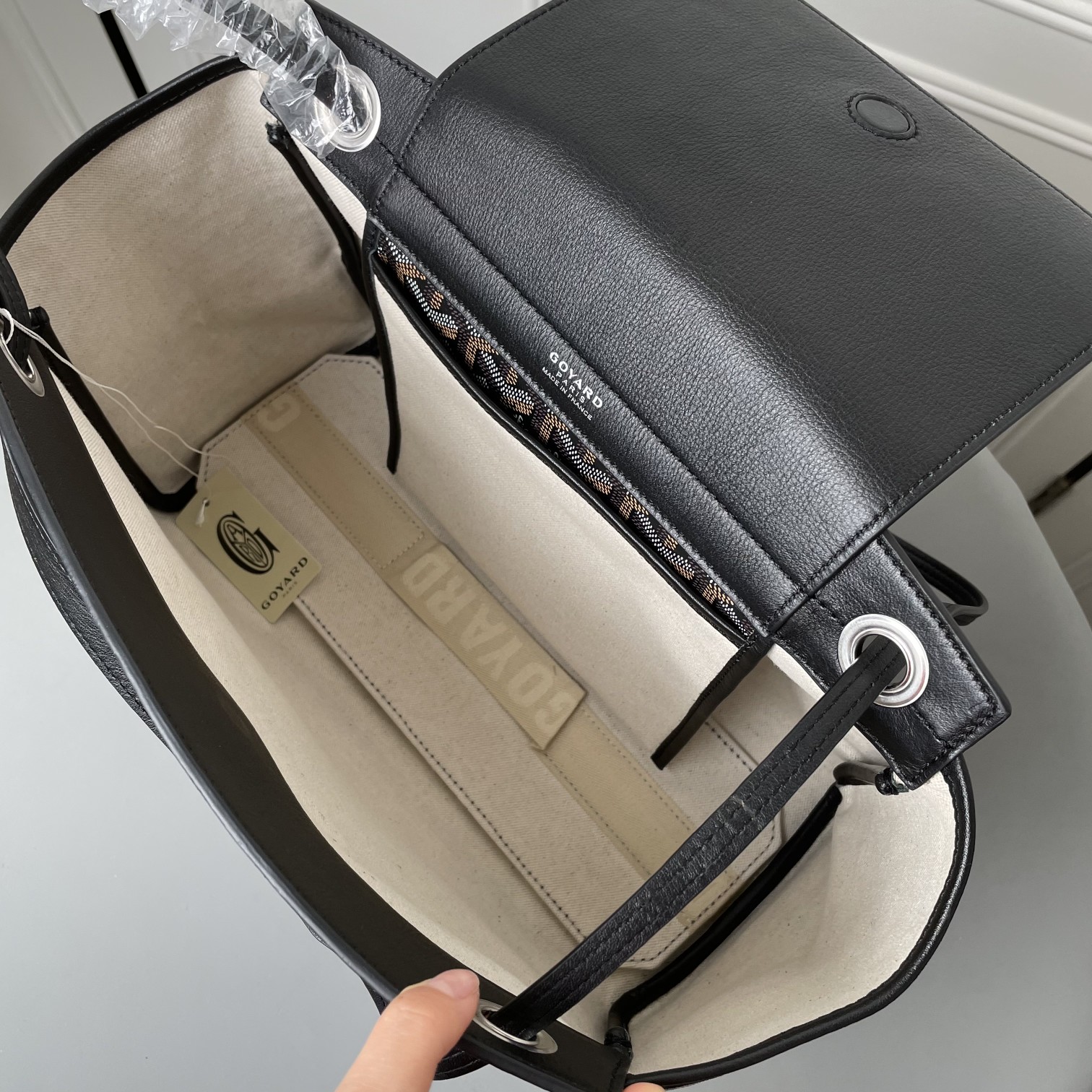 💰 650 戈雅 Rouette出货，目前我们手上可供选择的购物袋款型现货有三款：有至经典又轻巧柔软的saint Louis tote，有迎合国人喜好的袋口有拉链包身相对硬挺的Artois购物袋。还有这款刚刚出货的 Goyard Rouette.
相对其他款，这款Rouette造型更为规整，双层加厚面料，包身更显硬挺，包底有活动支撑板，能保证在负重时包底不下坠。
包身造型可变，两侧可收入变成另一个包型，肩带有多种背法（网传有22种）这个我也没有仔细的深入研究，有兴趣的可以自己上网看看或者买回去自行研究一下。
肩带穿过包身两侧，负重时包包会自动封口，袋口处有一个双面皮质的盖子，可拿出来也可放在包内。
既能代替拉链的防盗防漏功能，又免去了反复开合拉链的麻烦，更增加了包包的多变造型。是这款包的设计亮点。肩带的中间段，做了加宽对设计，可以让肩背感觉更舒服，也是非常贴心的设计。