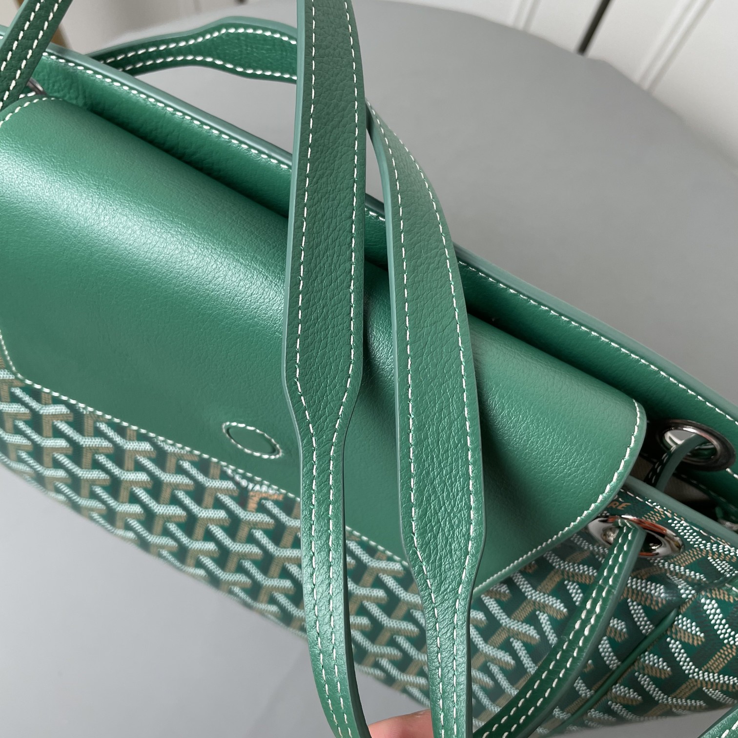 💰650 戈雅 Rouette出货，目前我们手上可供选择的购物袋款型现货有三款：有至经典又轻巧柔软的saint Louis tote，有迎合国人喜好的袋口有拉链包身相对硬挺的Artois购物袋。还有这款刚刚出货的 Goyard Rouette.
相对其他款，这款Rouette造型更为规整，双层加厚面料，包身更显硬挺，包底有活动支撑板，能保证在负重时包底不下坠。
包身造型可变，两侧可收入变成另一个包型，肩带有多种背法（网传有22种）这个我也没有仔细的深入研究，有兴趣的可以自己上网看看或者买回去自行研究一下。
肩带穿过包身两侧，负重时包包会自动封口，袋口处有一个双面皮质的盖子，可拿出来也可放在包内。
既能代替拉链的防盗防漏功能，又免去了反复开合拉链的麻烦，更增加了包包的多变造型。是这款包的设计亮点。肩带的中间段，做了加宽对设计，可以让肩背感觉更舒服，也是非常贴心的设计。