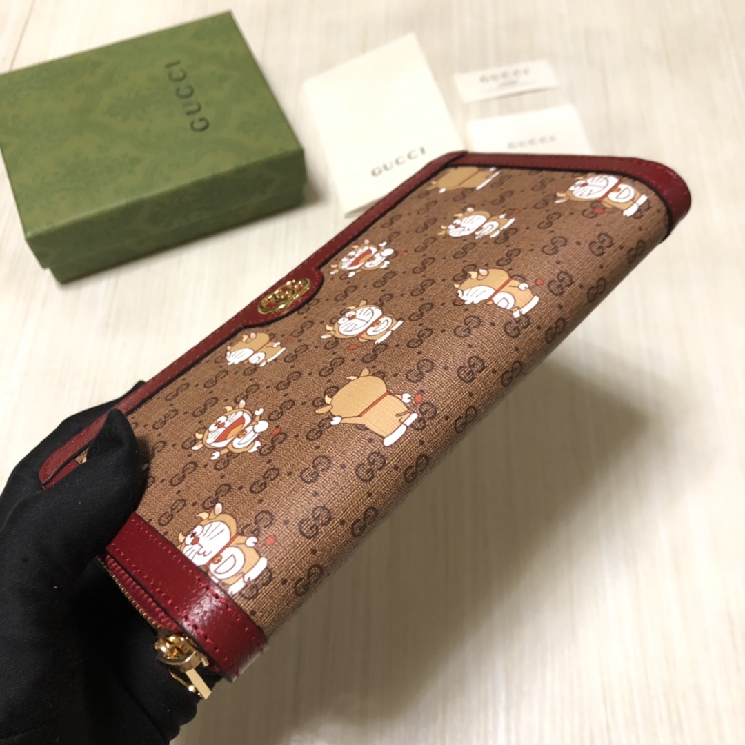 此款GG supreme帆布拉链钱包巧妙融入时光旅行机器猫的经典形象，童趣十足。这是品牌与哆啦A梦联手推
