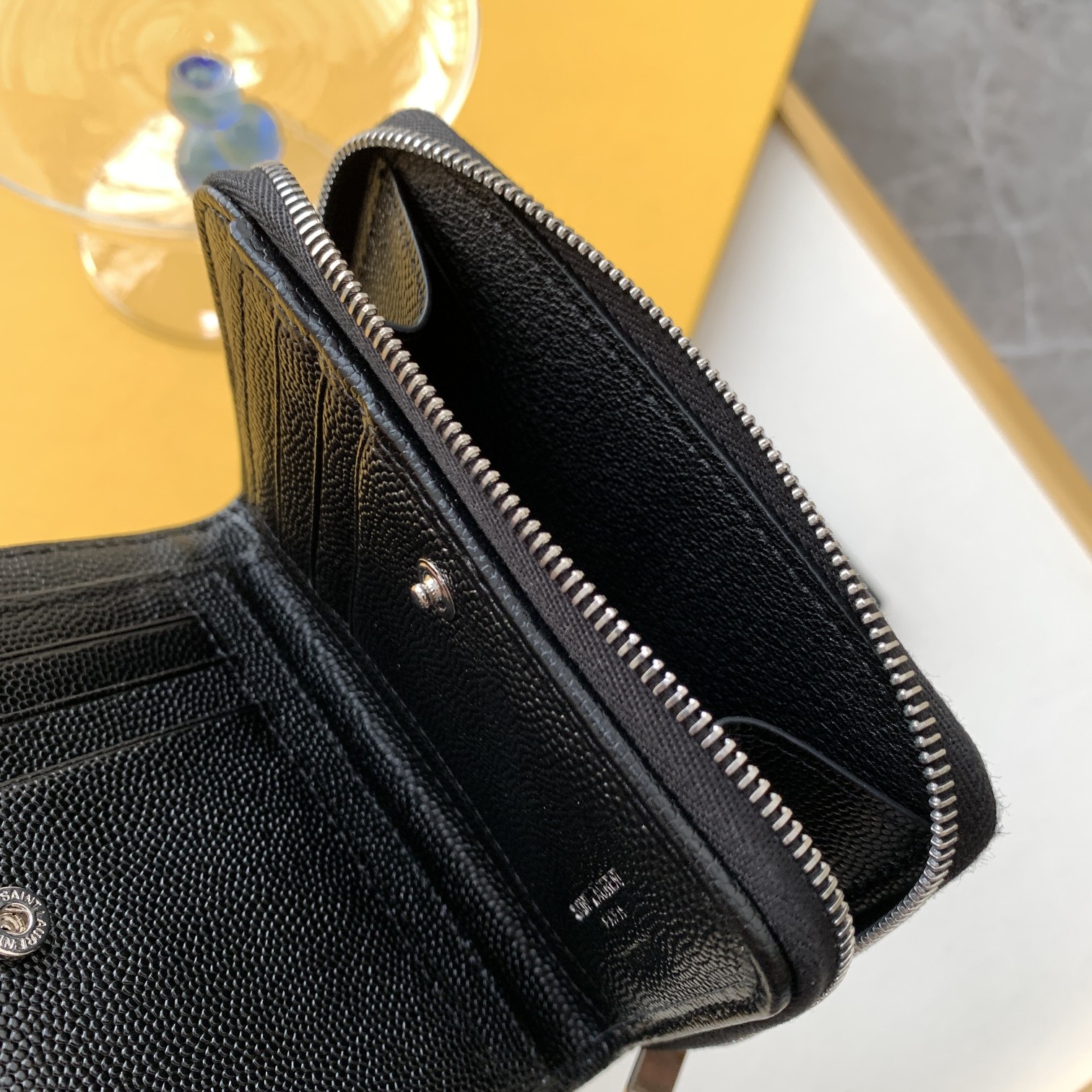 P300【特级精品 - 403723鱼子酱】🌸 配全套专柜最新包装📦
SLP 短款圆状拉链钱夹🎀  采用了黑色颗粒纹理牛皮皮革，搭配中央金色调金属联结YSL标志✅ 侧面打开有6⃣️个卡位，1⃣️个硬币袋👏👏
尺寸：12*10*3CM🍀