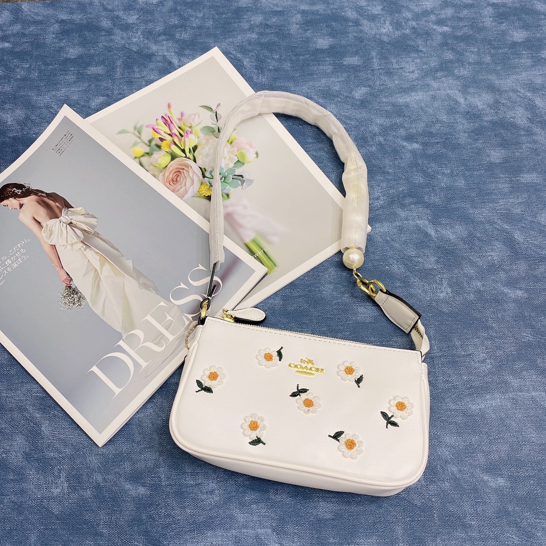 Coach蔻驰小雏菊麻将包🅿️170 小雏菊的每一朵小花都是立体的很有层次感.白色的细腻皮质搭配立体的小雏菊超nice.如果觉得麻将包的肩带太短 本店附赠一个珍珠链条一下就长了可以腋下背. 规格：19*11cm