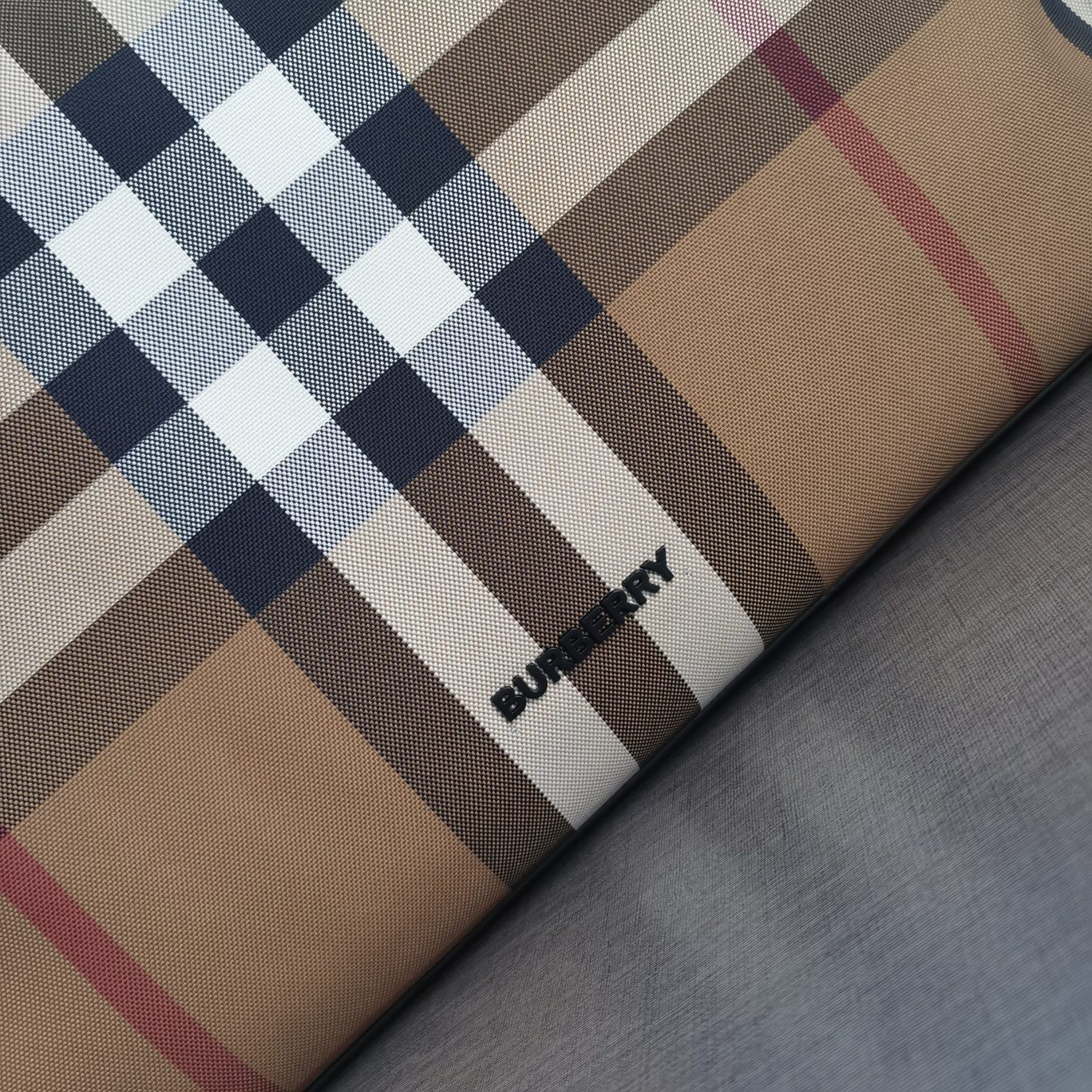 Burberry's large cotton plaid casual tote style "The Belt" is made of cotton canvas and flexible leather. It has a strap inspired by the brand's