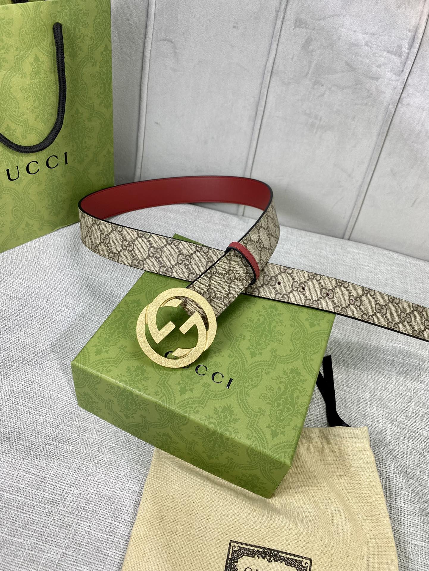 宽度4.0cm gucci 双面腰带，一侧为GG SuPreme帆布，反面一侧为枣红色头层小牛皮。配以互扣式双G压砂钢扣