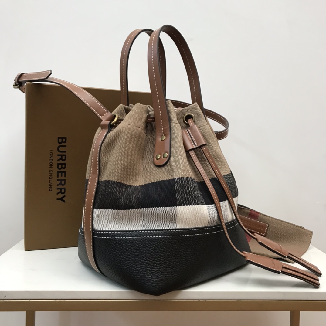 Burberry's durable Canvas original bucket bag with leather fringe detail. The top leather handle and shoulder strap allow it to be worn on the sh