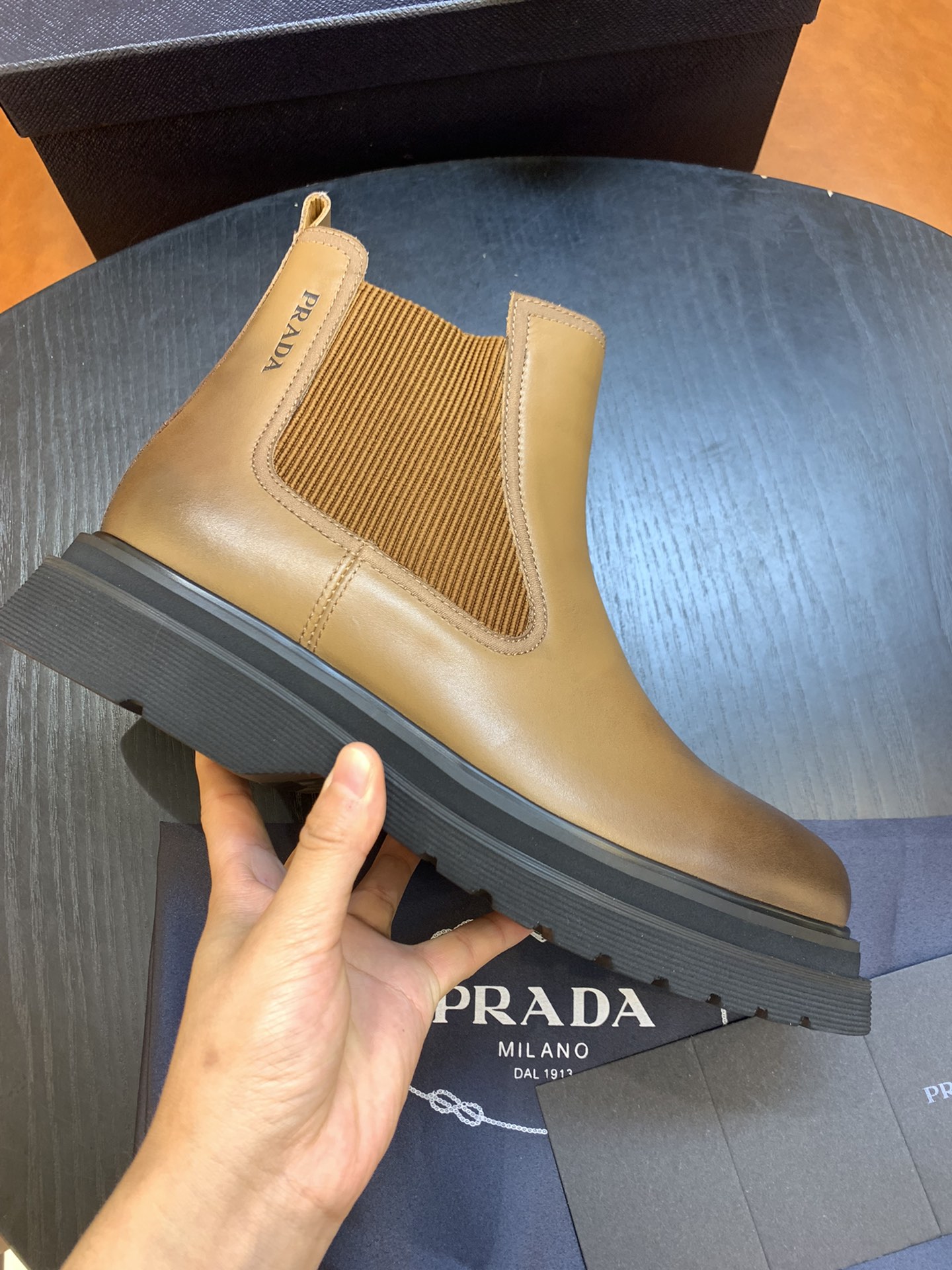Botas Chelsea auténticas de PRADA Esta sencilla bota Chelsea de piel de becerro está llena de encanto moderno. La piel …