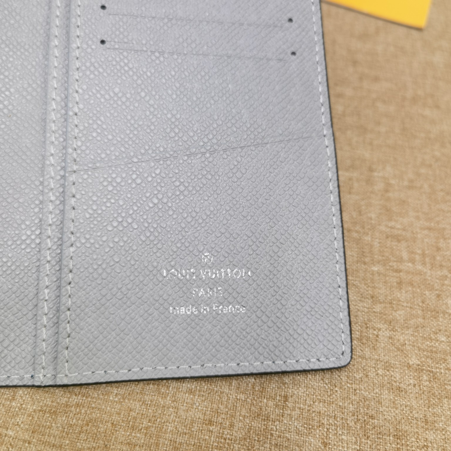 Close up of stitching on textured leather bifold wallet