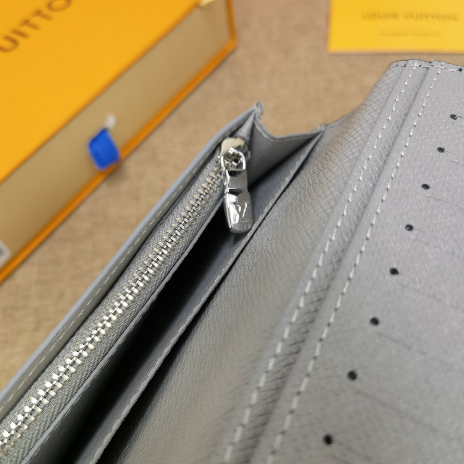 Textured leather bifold wallet in packaging