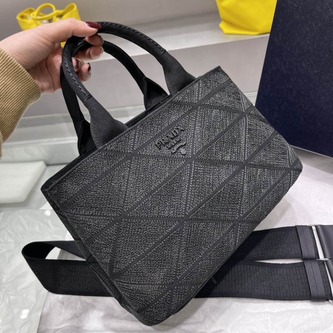 Prada 刺绣图案成为标志性 Prad#标志的表现形式 为这款棉质托特包打造通体质感 配饰配有可拆卸肩带和皮革手柄