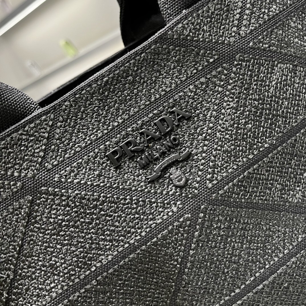 Prada 刺绣图案成为标志性 Prad#标志的表现形式 为这款棉质托特包打造通体质感 配饰配有可拆卸肩带和皮革手柄
