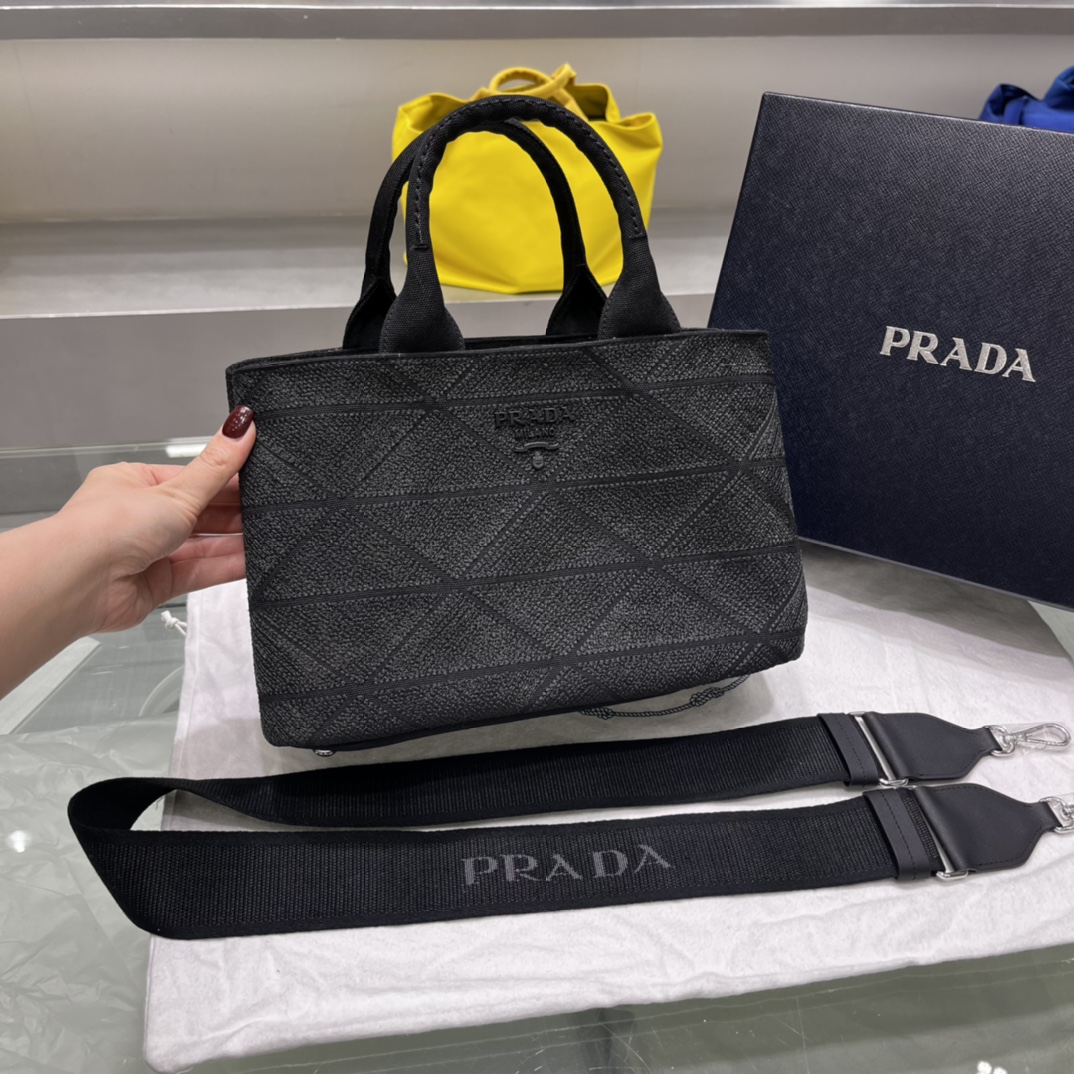 Prada 刺绣图案成为标志性 Prad#标志的表现形式 为这款棉质托特包打造通体质感 配饰配有可拆卸肩带和皮革手柄