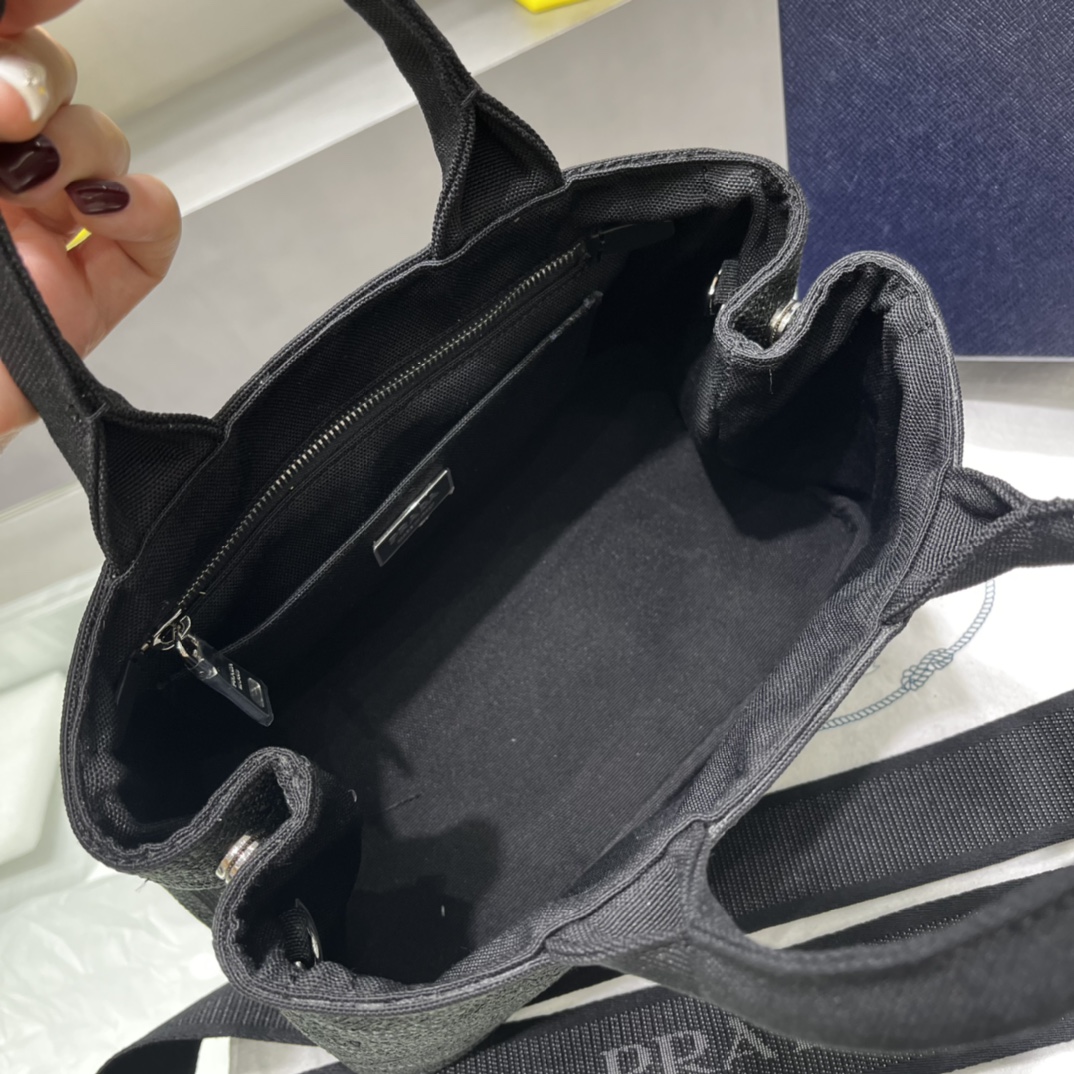 Prada 刺绣图案成为标志性 Prad#标志的表现形式 为这款棉质托特包打造通体质感 配饰配有可拆卸肩带和皮革手柄