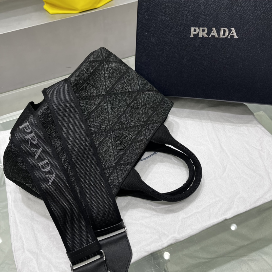 Prada 刺绣图案成为标志性 Prad#标志的表现形式 为这款棉质托特包打造通体质感 配饰配有可拆卸肩带和皮革手柄