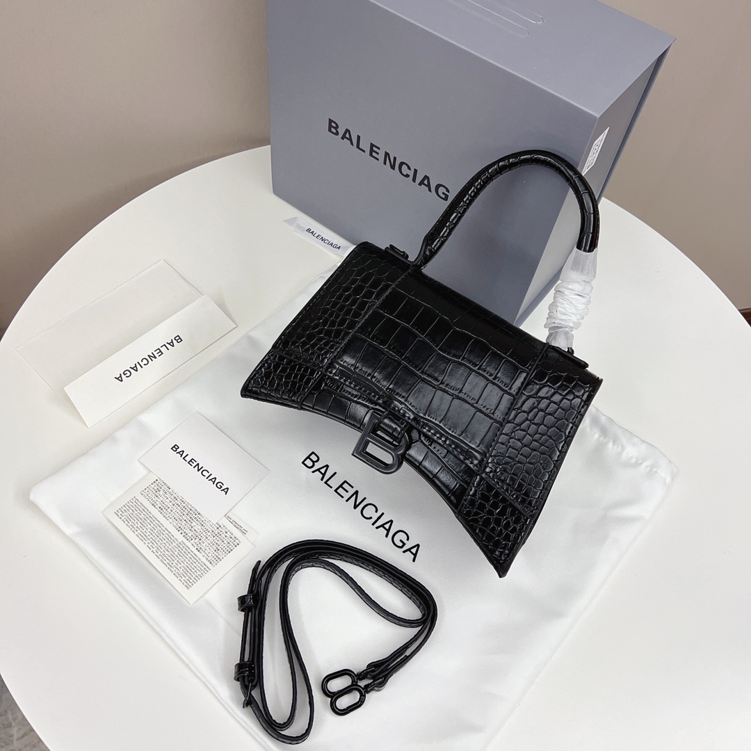 巴黎世家沙漏包 独特的标志性弧线形状造型.底部设置一个圆润光滑的拱形弧线.造型别致的同时还能避免包底被刮擦磨损.外观呈现一轮半月状.金属B形拉环垂坠在光面平整的表面上.牛皮质感也非常感人非常有腔调.爆款推荐. 规格:23*12*10cm