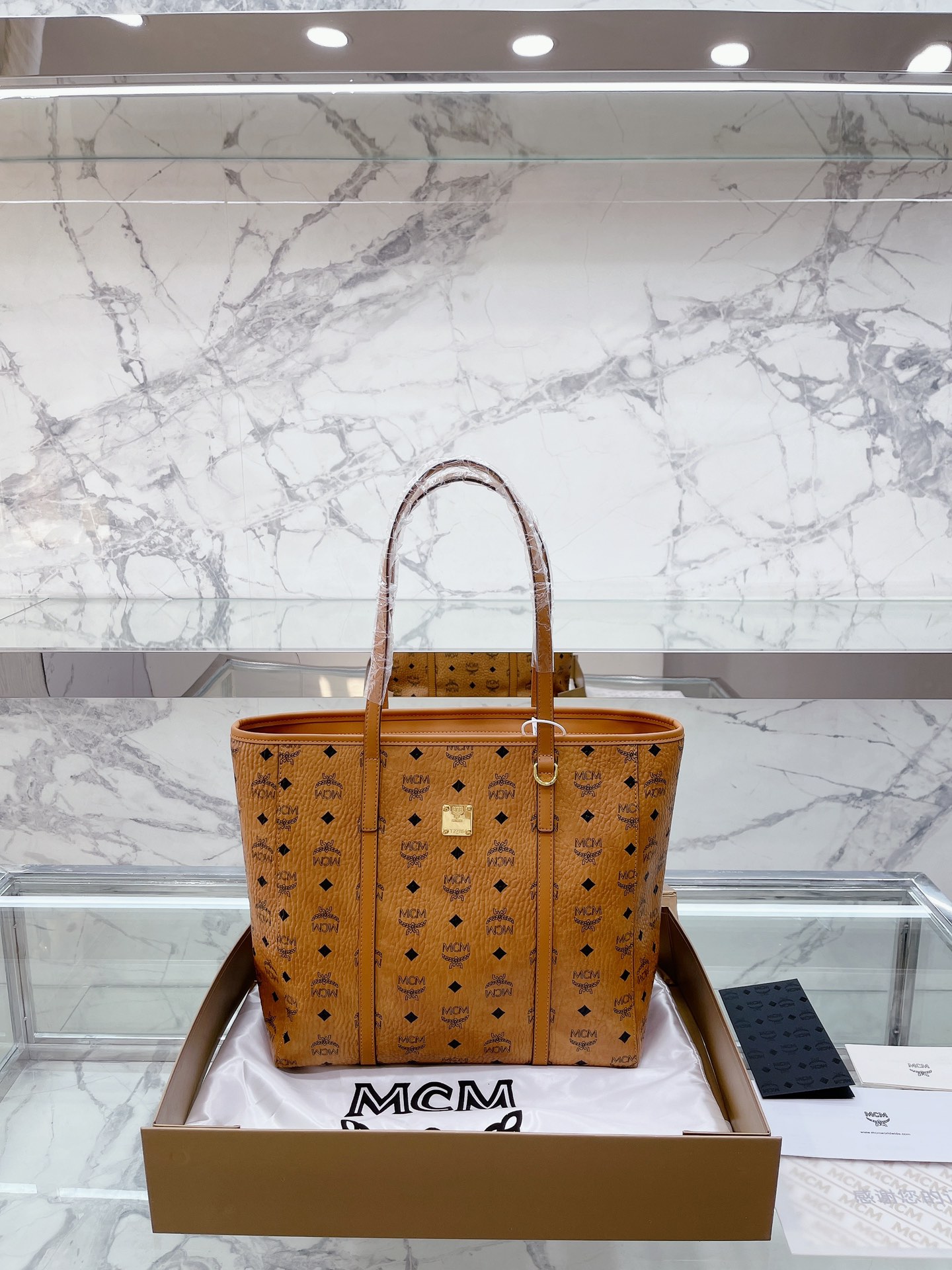 原单 牛皮 “复刻 牛皮版本” 全套礼盒包装 mcm新品手提袋，真是方便又实用哦运用精巧技艺所打造的经典 Visetos涂层帆布配件单品经久耐用，它的耐用度就如同其传奇之名我们经典的Visetos字母组合印花的涂层帆布成就了这款曲线利落的手提袋。耐用且具有标志性，它的可拆卸及可调节式人造革/牛皮革链条斜挎包肩带能随心所欲地实现任何您想要的造型。尺寸：32 32cm