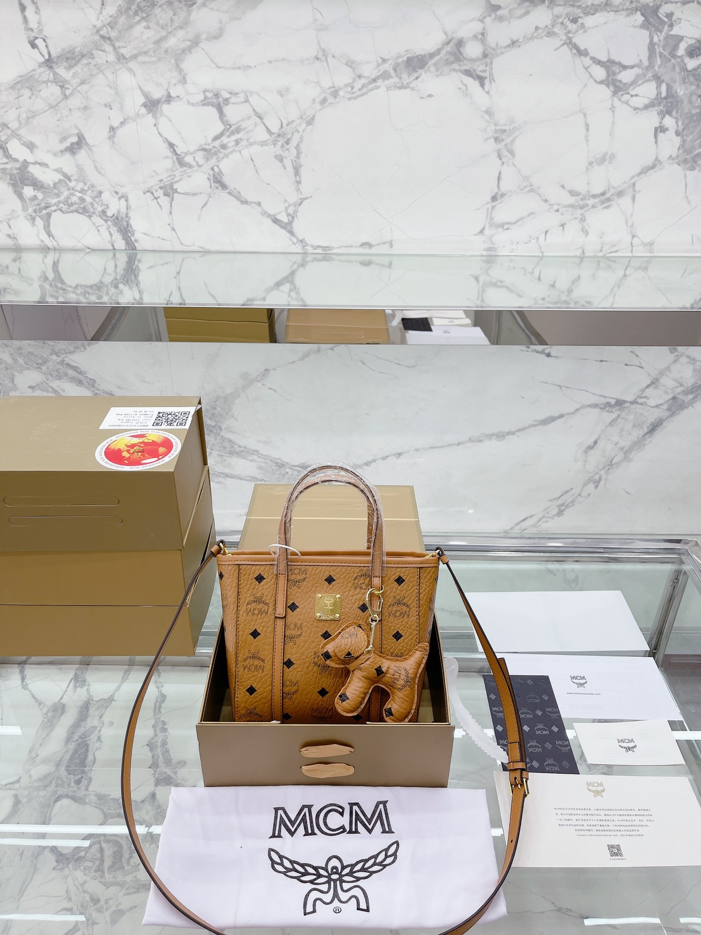 牛皮 升级款 配小狗挂件 MCM菜篮子|人人必备的单肩包|太百搭了 要说近几年MCM比较火的TOo款那就不得不把菜篮子放在第一位啦! 1.因为这个款式及其的百搭而且容量超级大很容易满足精致集美日常出街背带的必需品哦~ 2.外观就更不用说啦! -眼看上去就爱上了无论你是@ 可可爱爱的双马尾制服女孩，还是文艺清 新的女神饭又或者是职场小白领这款包包都能帮你搭配出你想要的feel哦~让你无时无刻都觉得很适合你哦~ 3.说了那么多价格最关键!这点很重要哦~划重点这款是MCM家为数不多白菜价价的爆款! 因为据我所知这款包包一直断货是可遇不可求的款 20*22