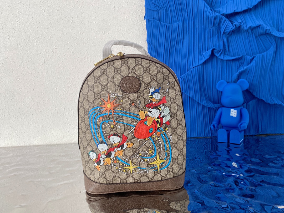 255  Gucci 古奇   联名Disney 迪士尼 GG唐老鸭 印花背包 中性款双肩包 采用原厂材质 高端货 专柜货号 552884配送小票防尘袋 30 x 22 cm。