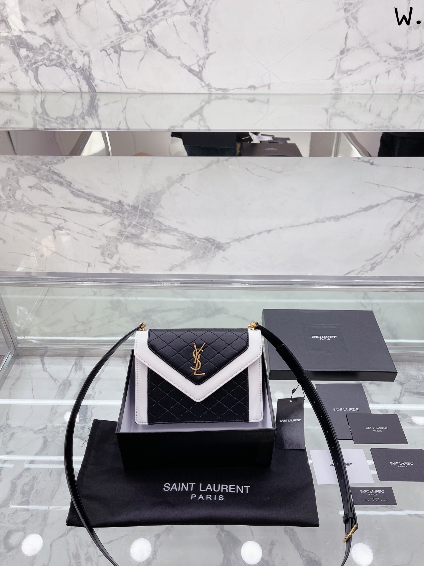 小号Saint Laurent 圣罗兰 YSL  Saint Laurent新作以几何绗缝为主要设计亮点，延续 Saint Laurent 圣罗兰 YSL 女郎的优雅独立气质。全新Gaby手袋采用信封式翻盖搭配利落包身,简约黑白色调随心切换于日常休闲或派对晚宴。LeMaillon系列新增小方包和拉链包型，古铜色锁链肩带充满复古学院气息。 .Gaby肩背包. 全新Gaby肩背包是秋冬系列广告片主角，灵感来自法 国电影八美图8 Femmes，2002 中CatherineDeneuve饰演的角色Gaby,代表独立自主的女性形象。包包采用线条利落的矩形轮廓搭配复古的信封式翻盖，包身选用柔软小羊皮制成，点缀绗缝菱格纹并以平滑边框勾勒，充满摩登率性格调。内部为双隔间设计,皮革肩带调节长度为33cm-50cm。 2Gaby链条包的外观更接近信封，正面内层为绗缝菱格纹，翻盖和底部三角拼接光滑皮革，链条肩带让包包显得更有女人味。20cm