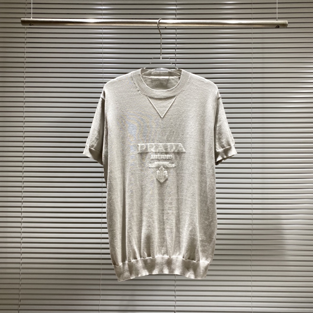 Prada pra suéter de punto de cuello redondo con insignia en el pecho, manga corta. Colores: azul, gris, blanco. Tallas:…