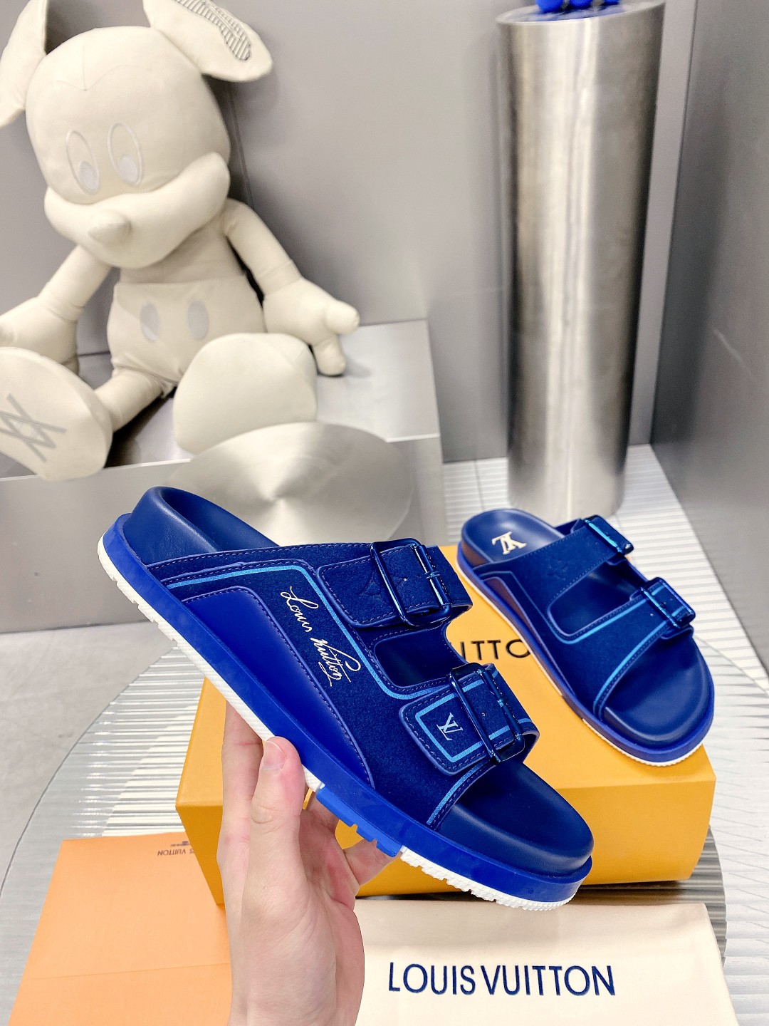 .Esta sandalia LV Trainer une la esencia del diseño de la zapatilla LV Trainer con una interpretació