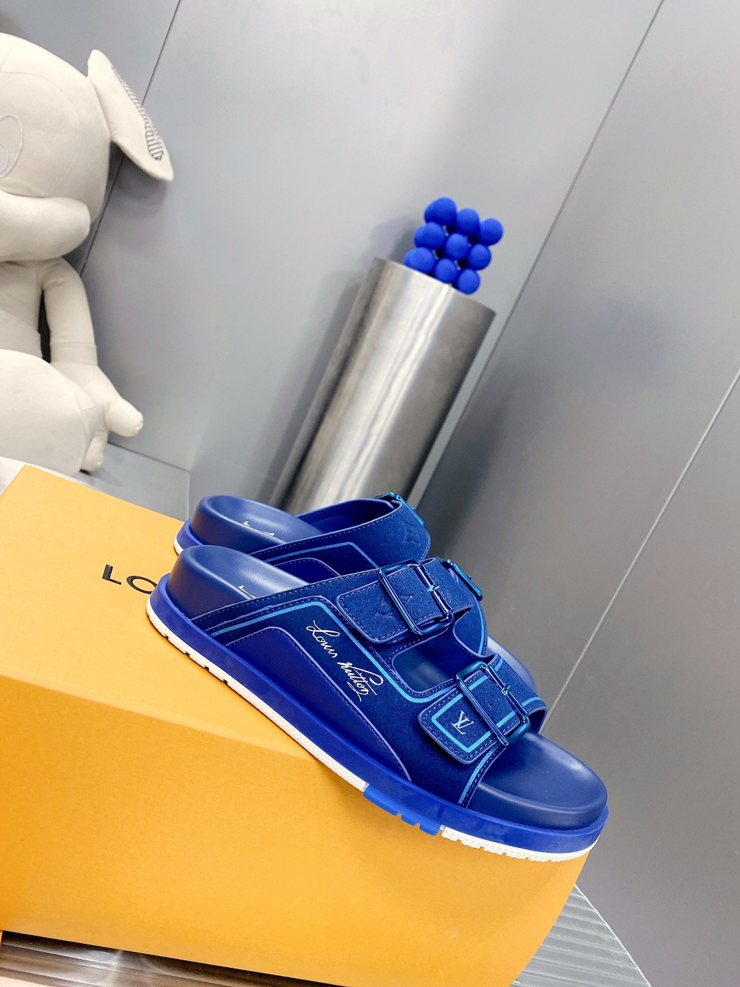 .Esta sandalia LV Trainer une la esencia del diseño de la zapatilla LV Trainer con una interpretació