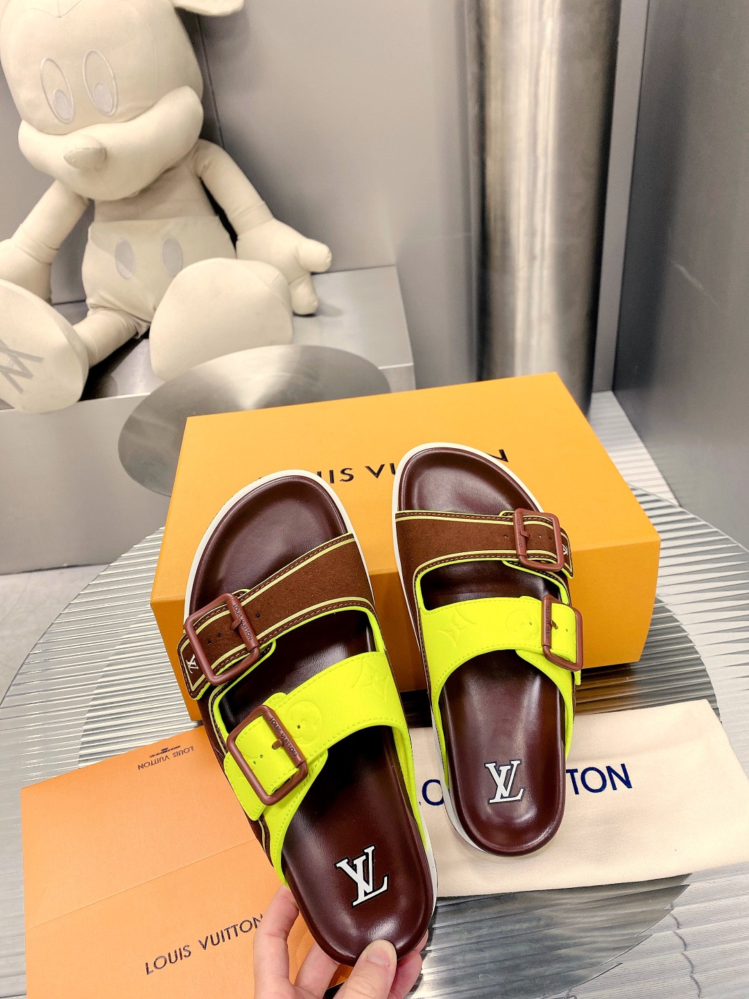 .Esta sandalia LV Trainer une la esencia del diseño de la zapatilla LV Trainer con una interpretació