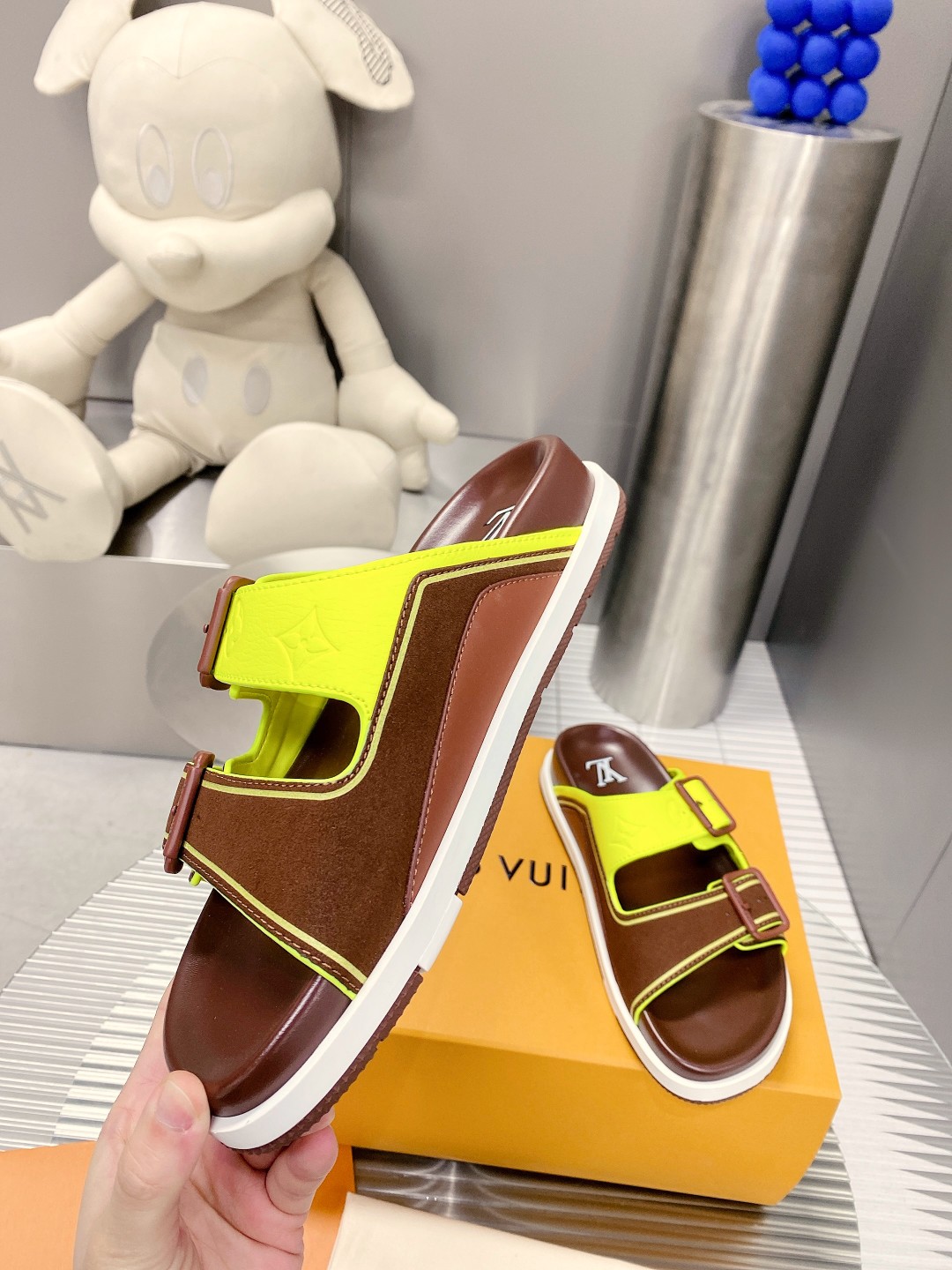 .Esta sandalia LV Trainer une la esencia del diseño de la zapatilla LV Trainer con una interpretació