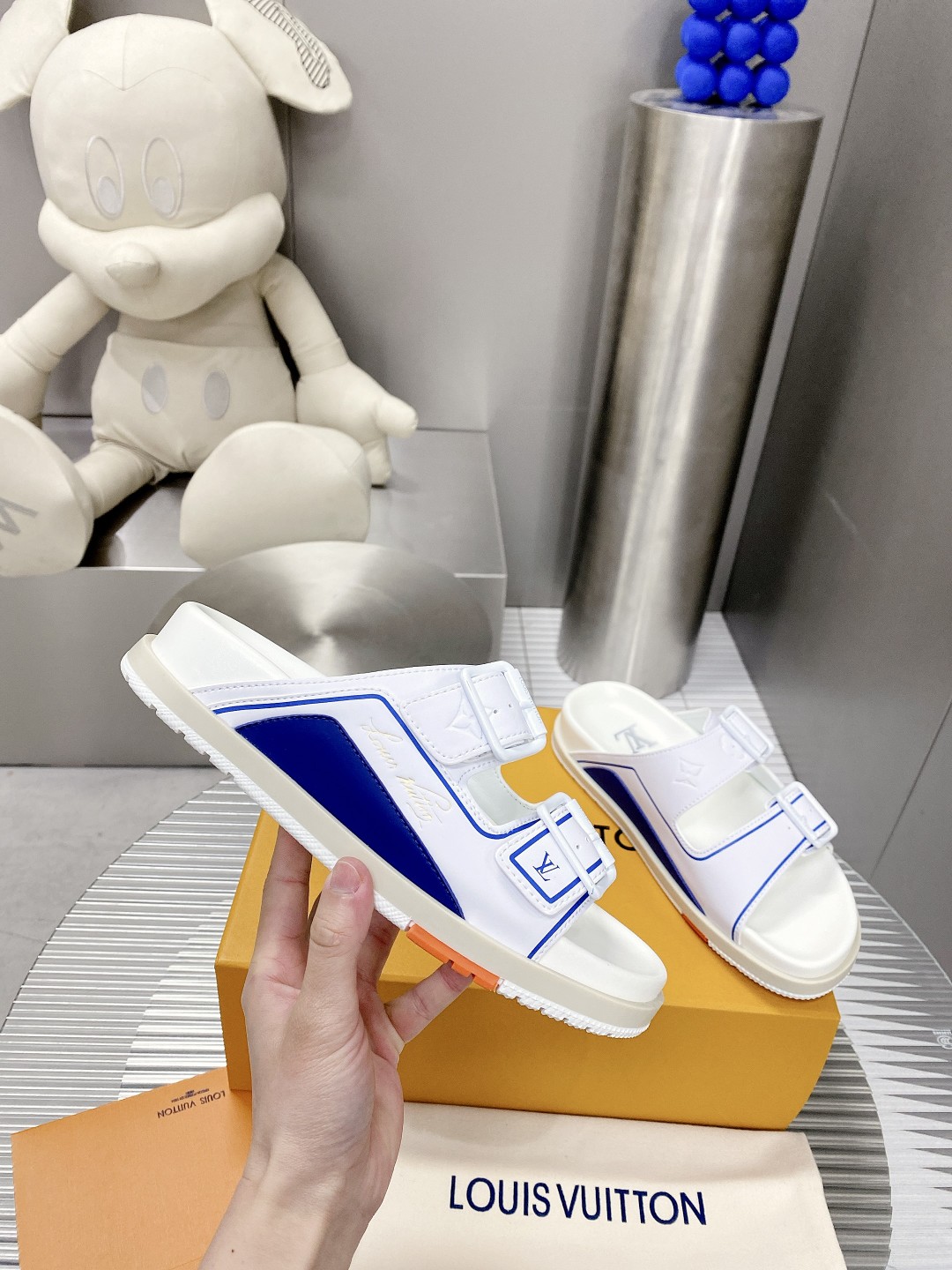 .Esta sandalia LV Trainer une la esencia del diseño de la zapatilla LV Trainer con una interpretació
