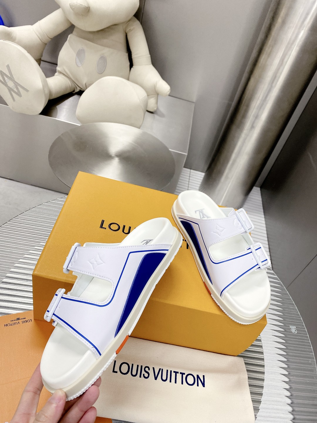 .Esta sandalia LV Trainer une la esencia del diseño de la zapatilla LV Trainer con una interpretació