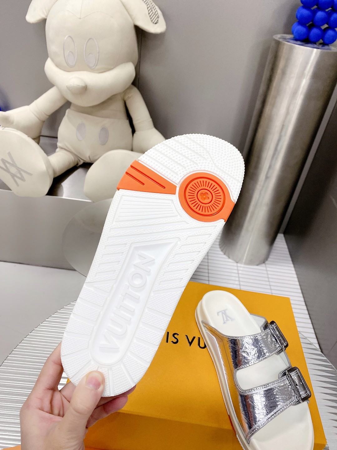 .Esta sandalia LV Trainer une la esencia del diseño de la zapatilla LV Trainer con una interpretació
