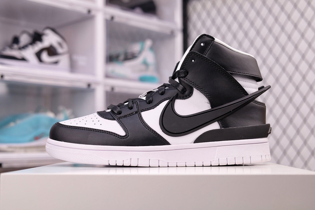 I0 Nike AMBUSH x SB Dunk High 滑板鞋高帮 黑白大勾 吴亦凡同款 真标原盒 正确细节 小红书代购平台专供 以早年间最经典的 Dunk Hi 为蓝本，通过黑白撞色与夸张 Swoosh 的视觉冲突，营造复古气氛之下的时尚气质。服饰方面则采用洛杉矶湖人和布鲁克林篮网 Logo 为核心，将训练服饰进行重新演绎。贯穿双肩的醒目标志，视觉冲击极为强烈。 搭配黑白双色尽显街头气质。鞋款最大亮点在于侧身 Swoosh Logo 延至后跟并超过鞋身，以夸张设计带来辨识度的提升，醒目效果极强。鞋舌与后跟处均饰有 AMBUSH 字样，鞋款联名身份不言而喻