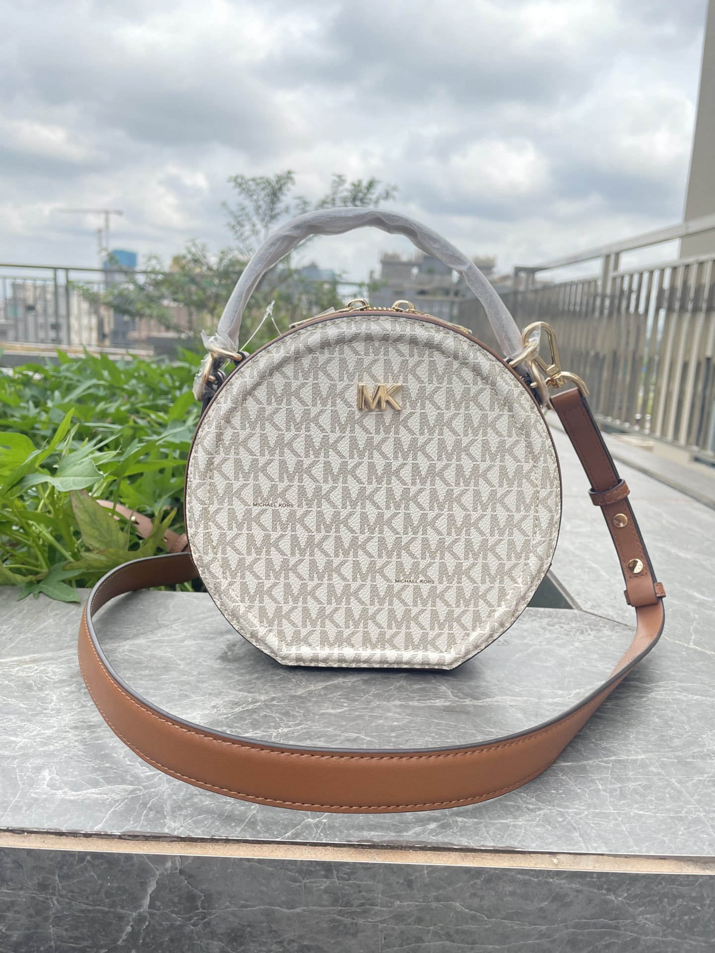 Michael Kors MK、新款Delaney 斜挎包采用 别致的圆饼造型 专为配合繁忙日程而设计 斜挎包以光滑皮革打造