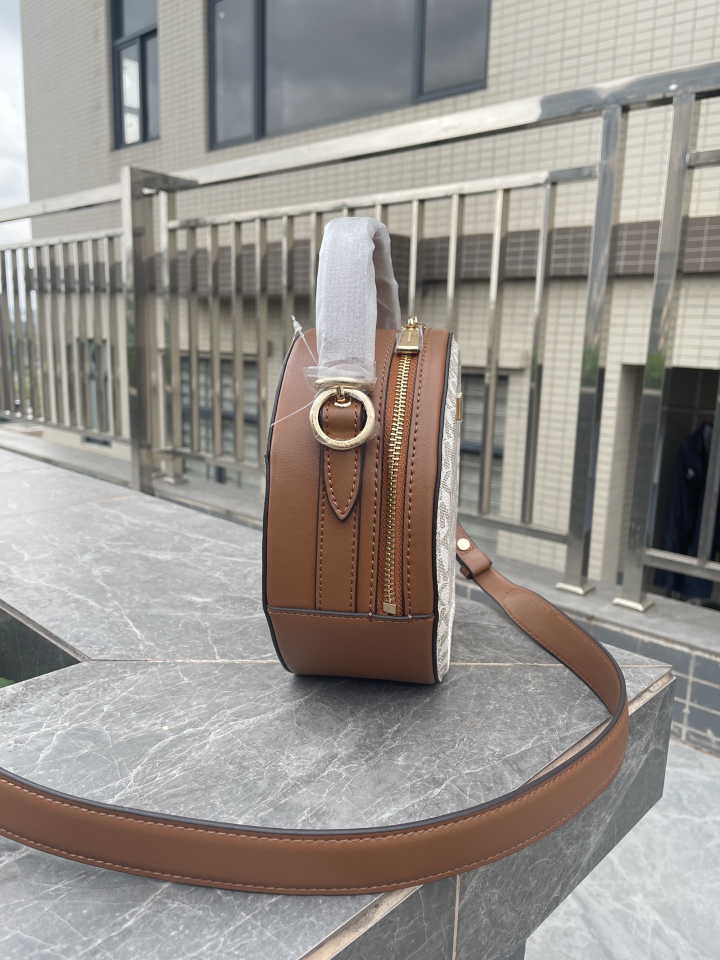 Michael Kors MK、新款Delaney 斜挎包采用 别致的圆饼造型 专为配合繁忙日程而设计 斜挎包以光滑皮革打造