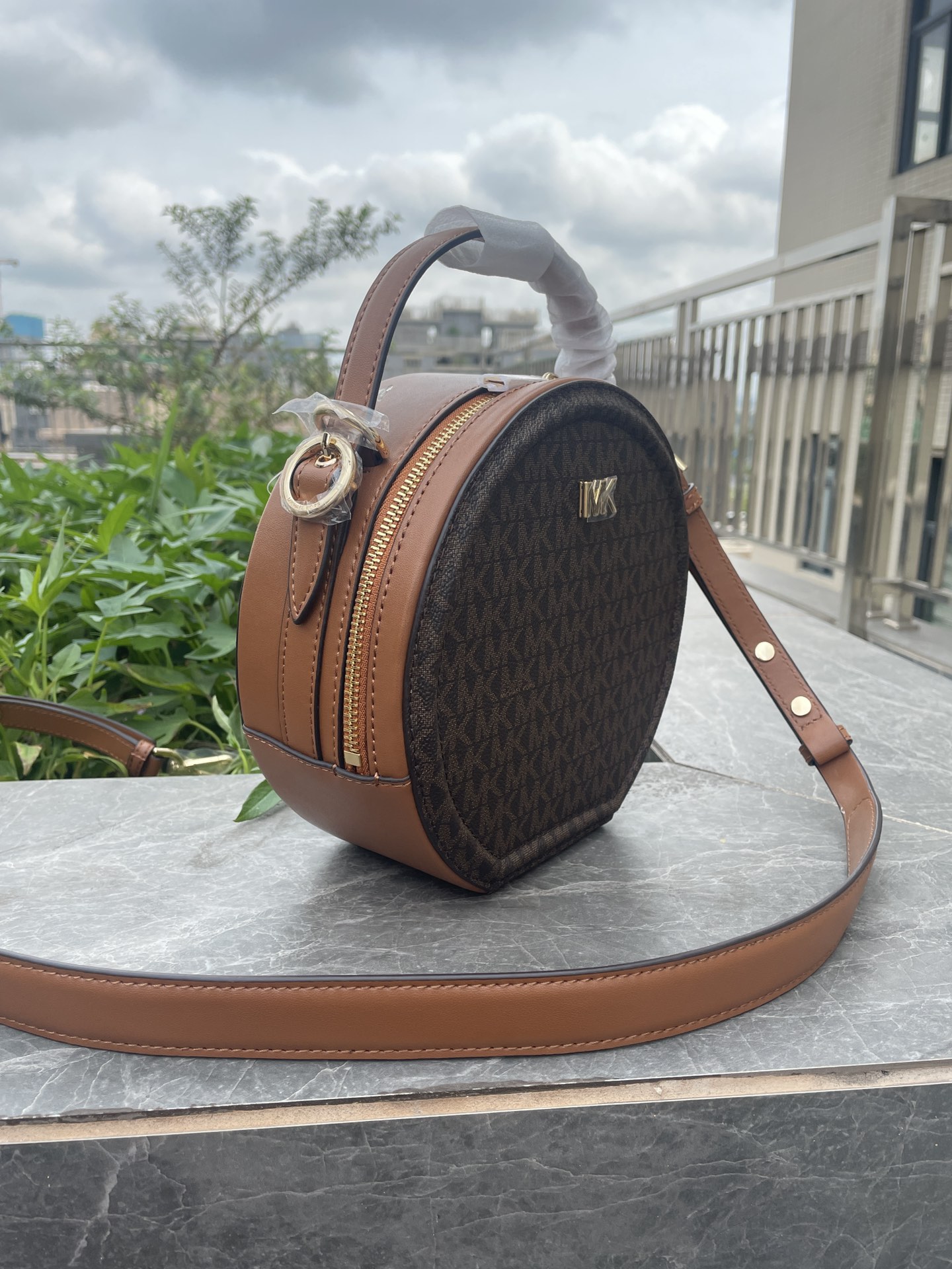 Michael Kors MK、新款Delaney 斜挎包采用 别致的圆饼造型 专为配合繁忙日程而设计 斜挎包以光滑皮革打造