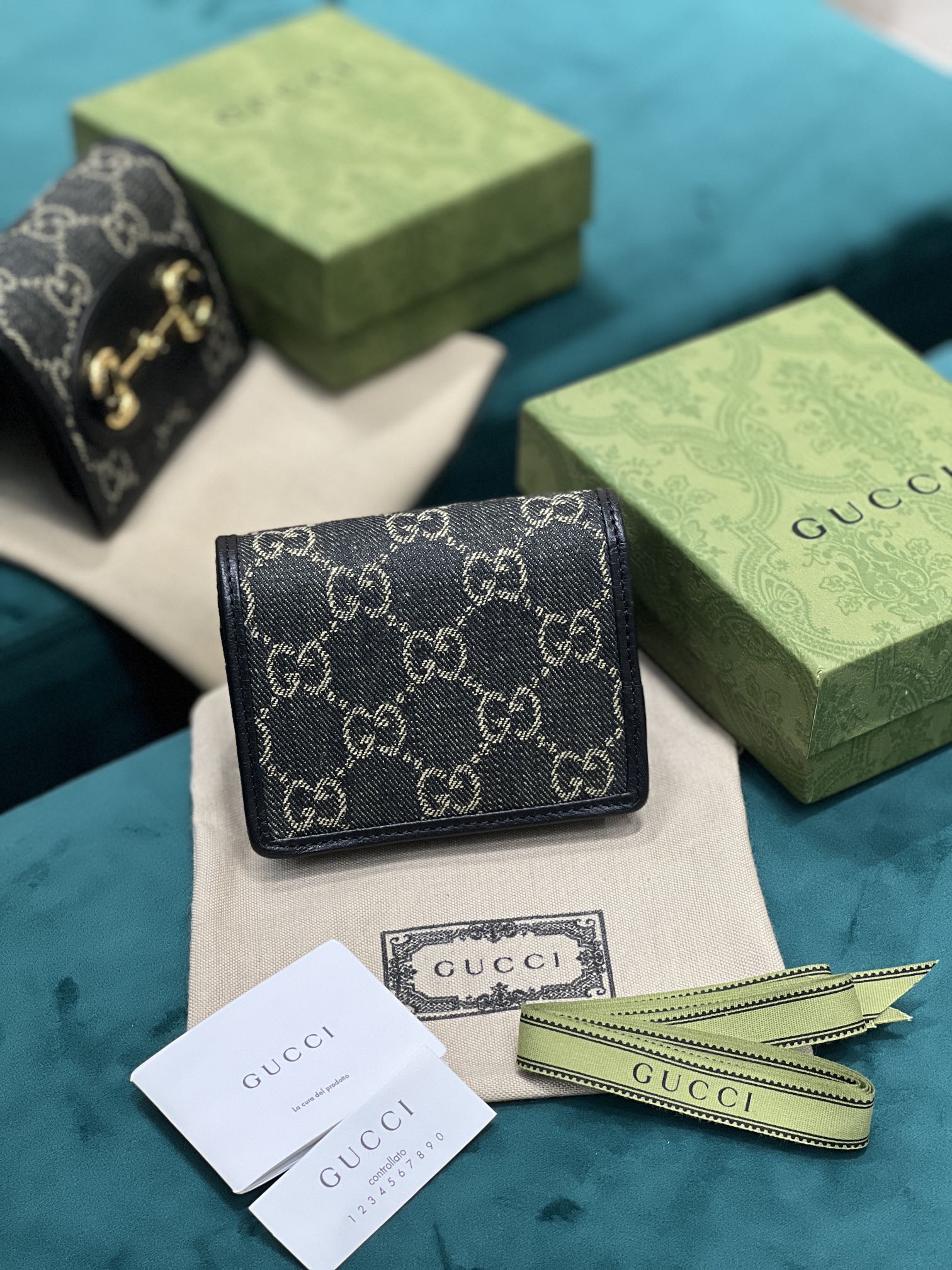 卡包 Gucci马衔扣1955系列不断发展壮大 Gucci 马衔扣1955系列小号卡包采用搭配黑色和象牙白色GG丹宁提花面料制作 621887